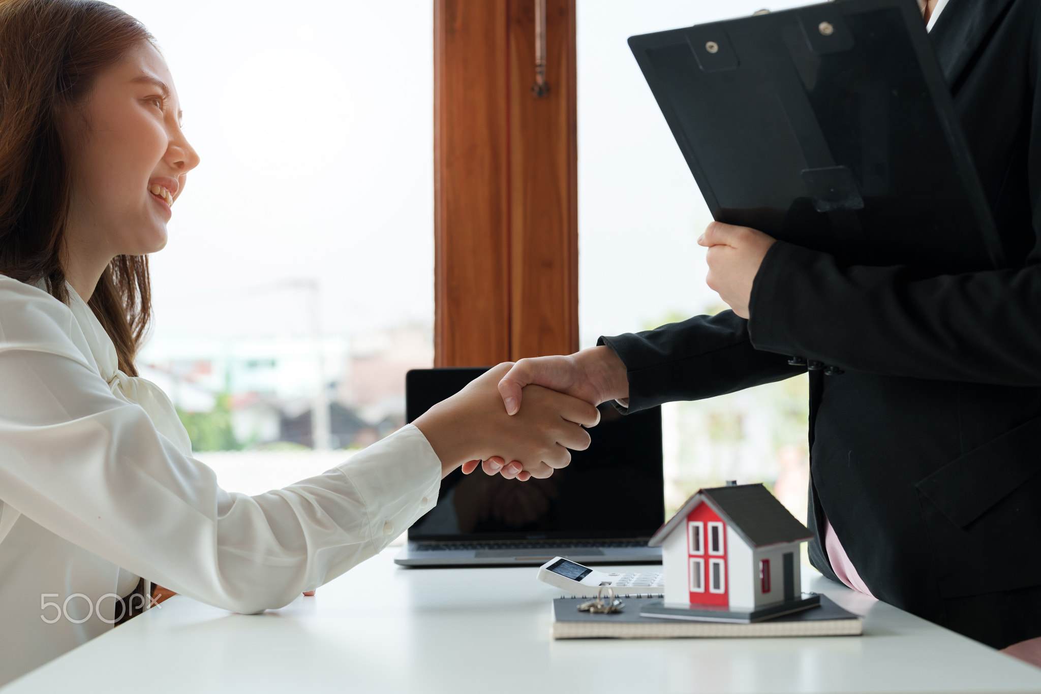 Estate agent and customer shaking hands after finished contract after