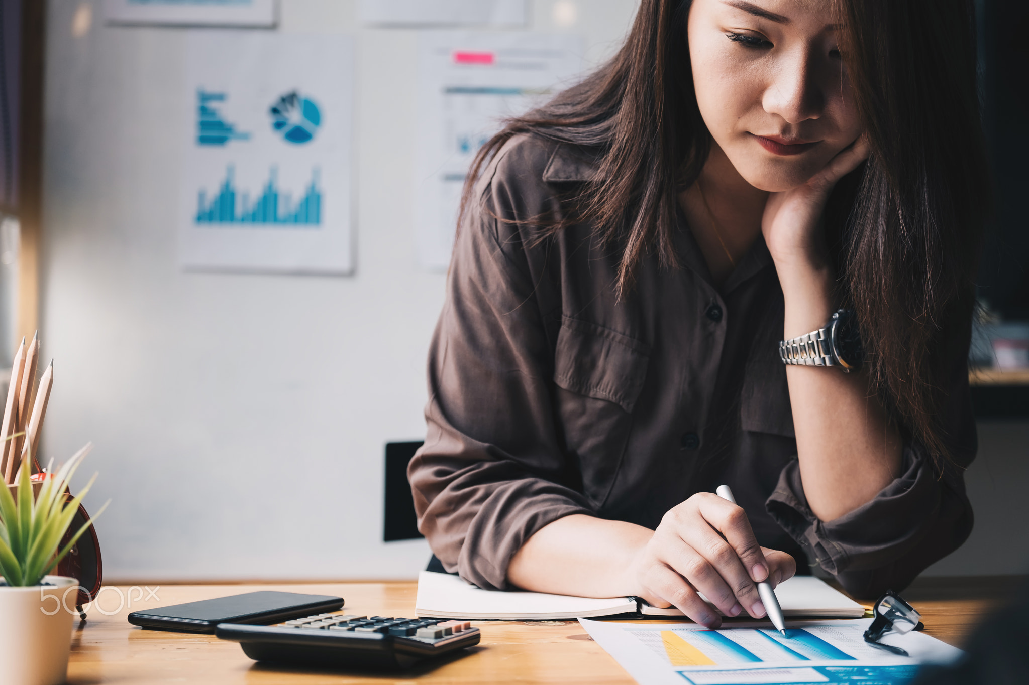 Business woman using calculator for do math finance on wooden desk in