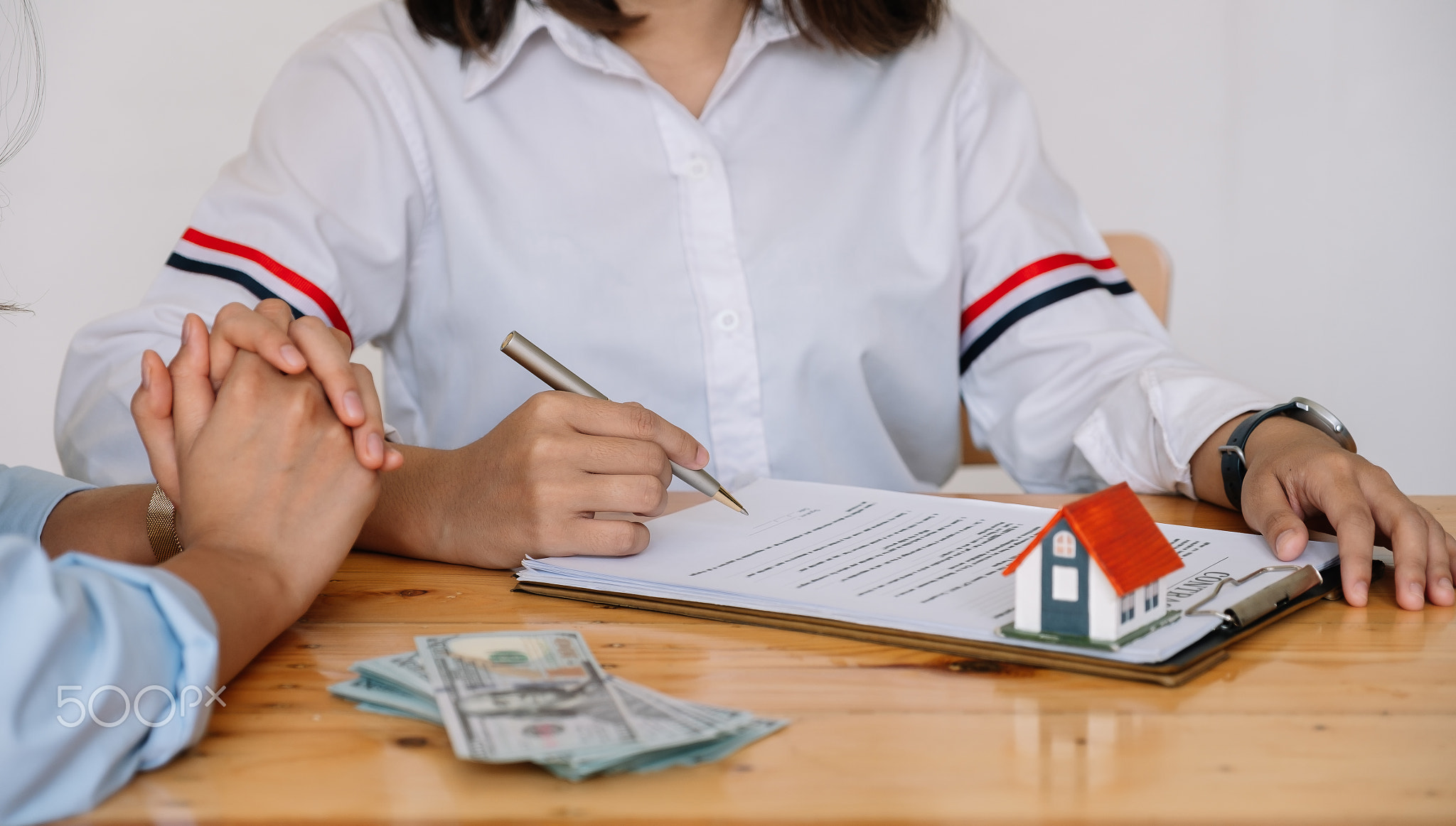 Cropped image of real estate agent assisting client to sign contract