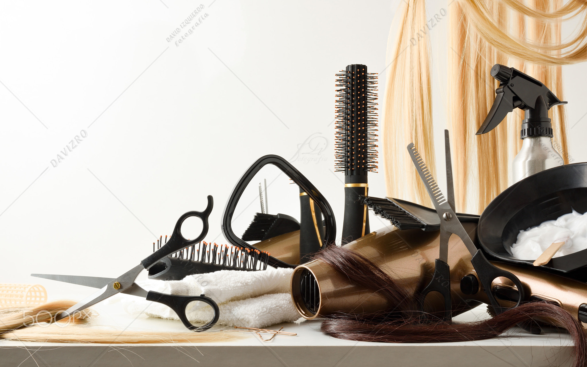 Hairdressing tools on table with hair extensions in the background