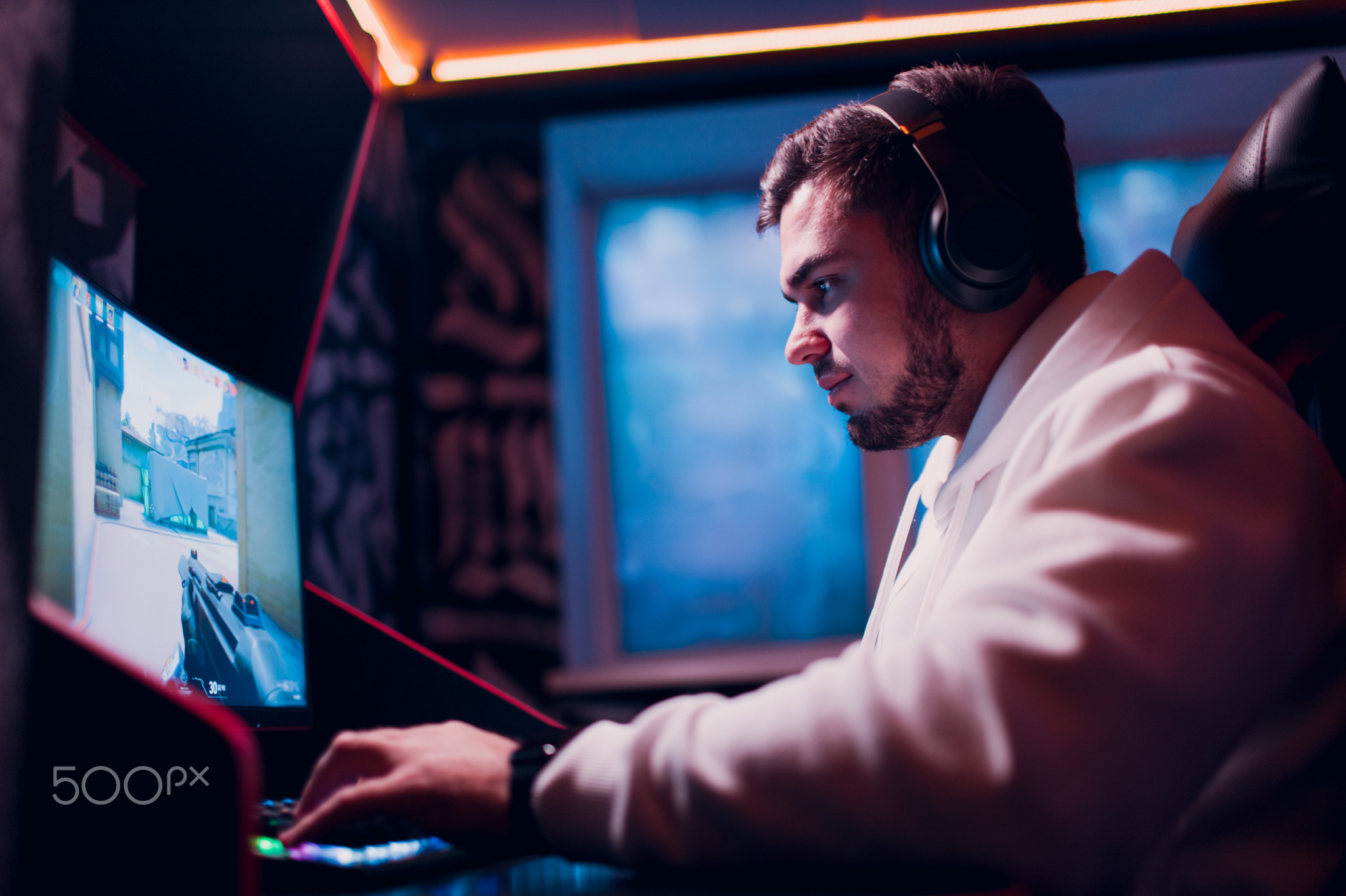 Guy playing gaming game on computer at game club