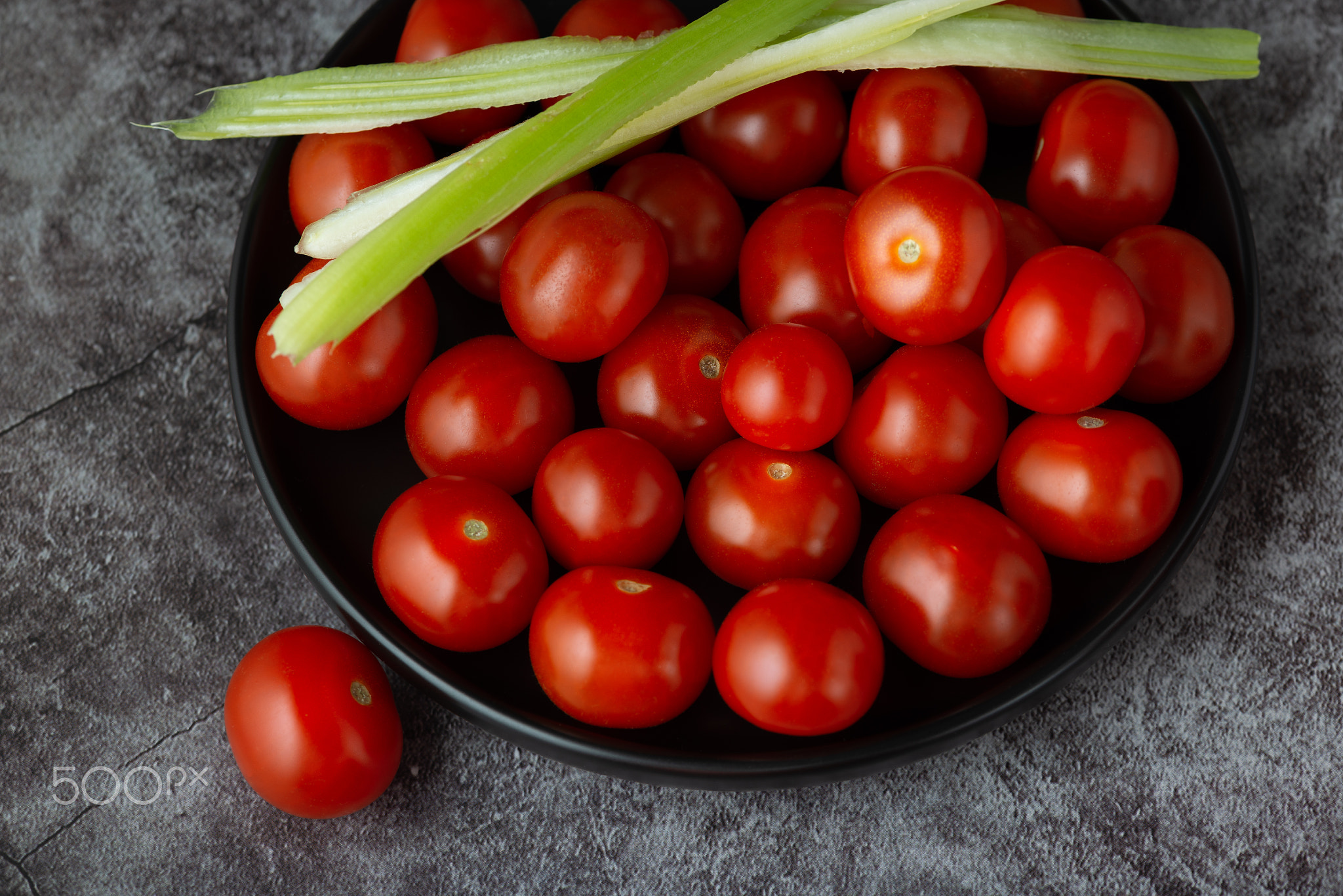 Bowl with cherry tomatoes on table, elevated view