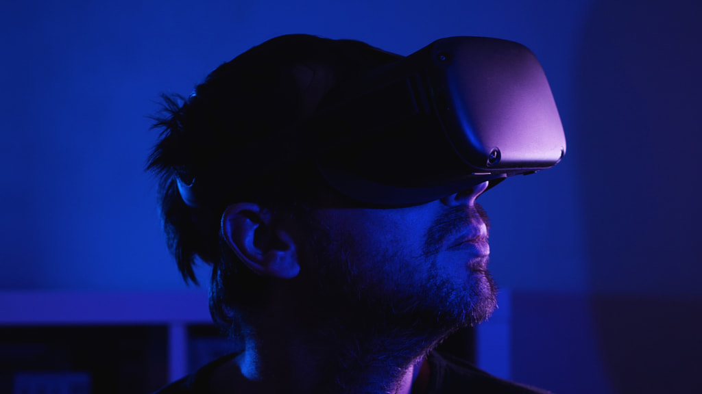 500px.com'da Vladimir Volovodov tarafından mavi ışıklı karanlık bir odada VR gözlükleri takan sakallı bir adam
