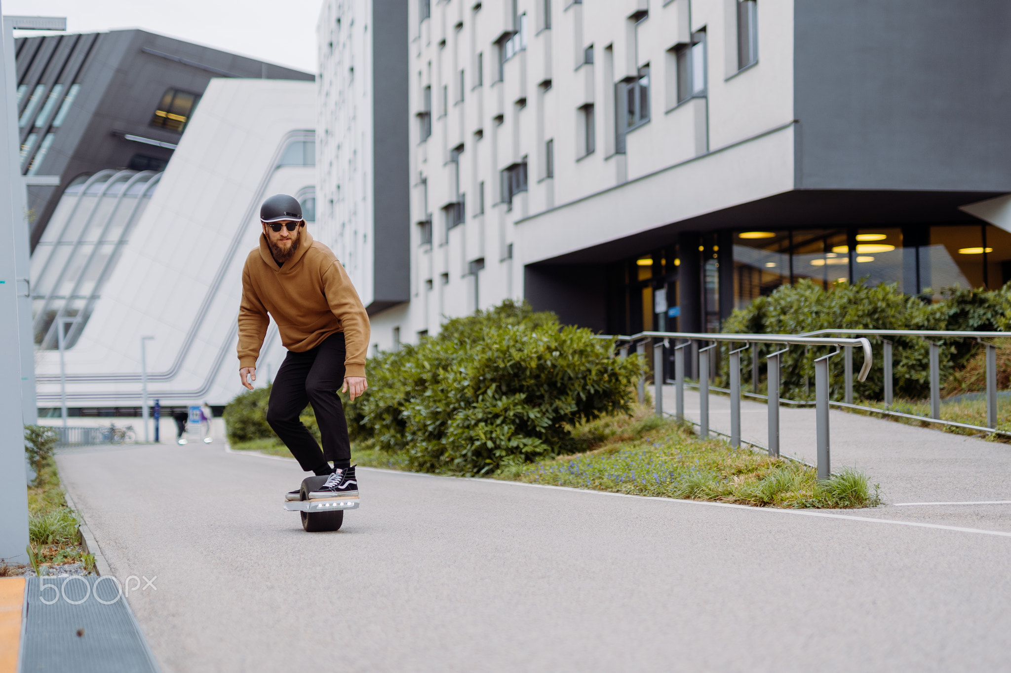 Young man in a helmet rides an electric skateboard. Onewheel rider in