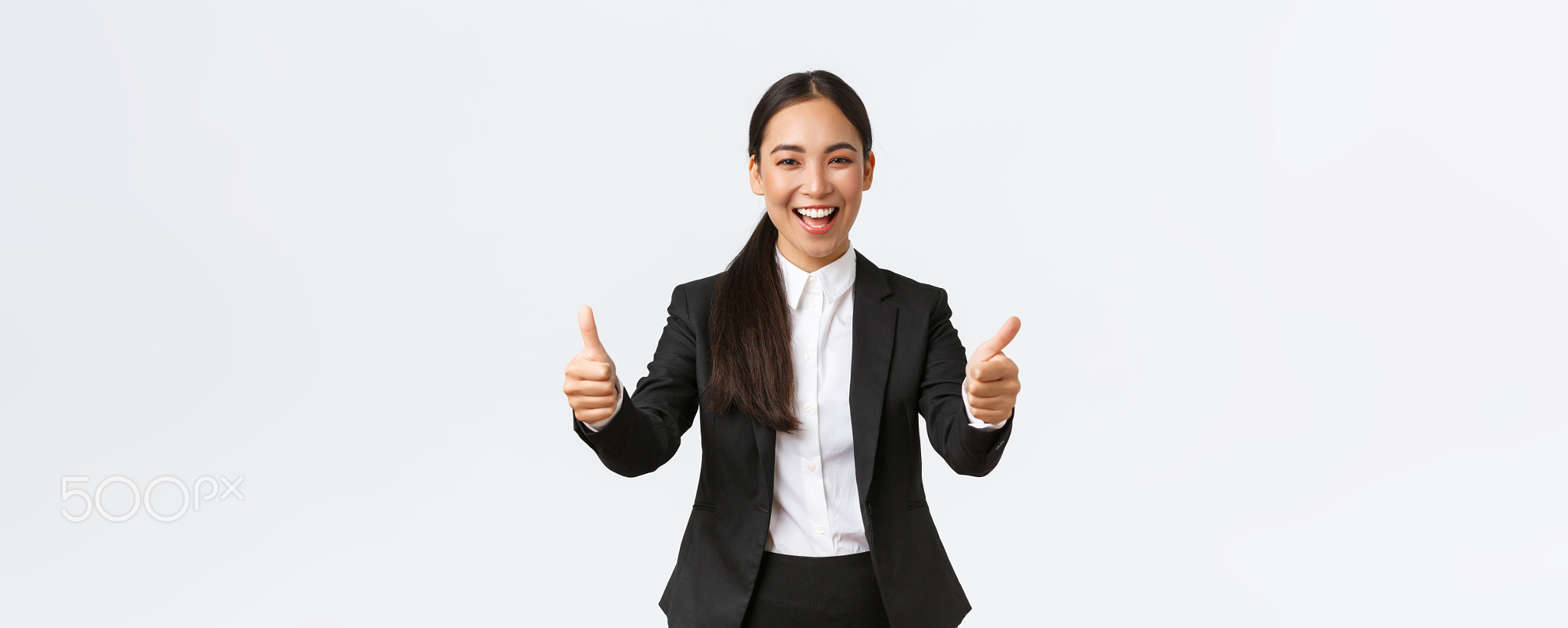 Successful upbeat asian businesswoman showing thumbs-up and smiling