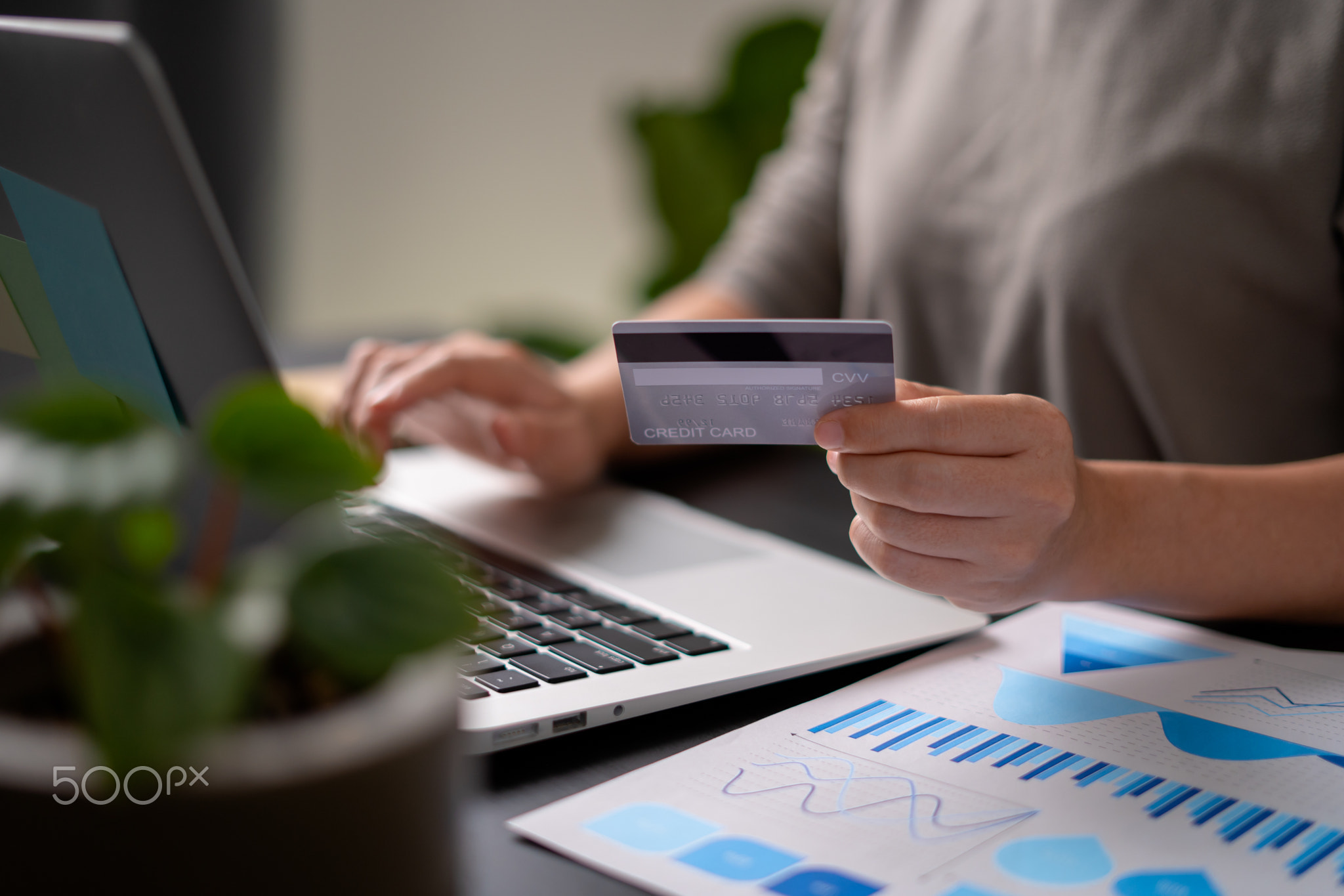 females hands holding credit card on laptop for shopping online.