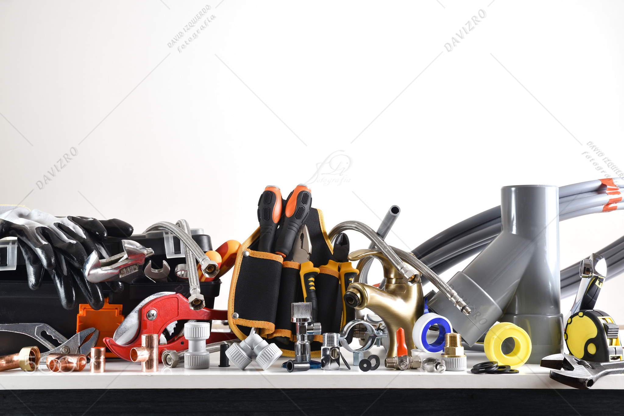 Sample of plumbing materials and tools on workbench isolated background