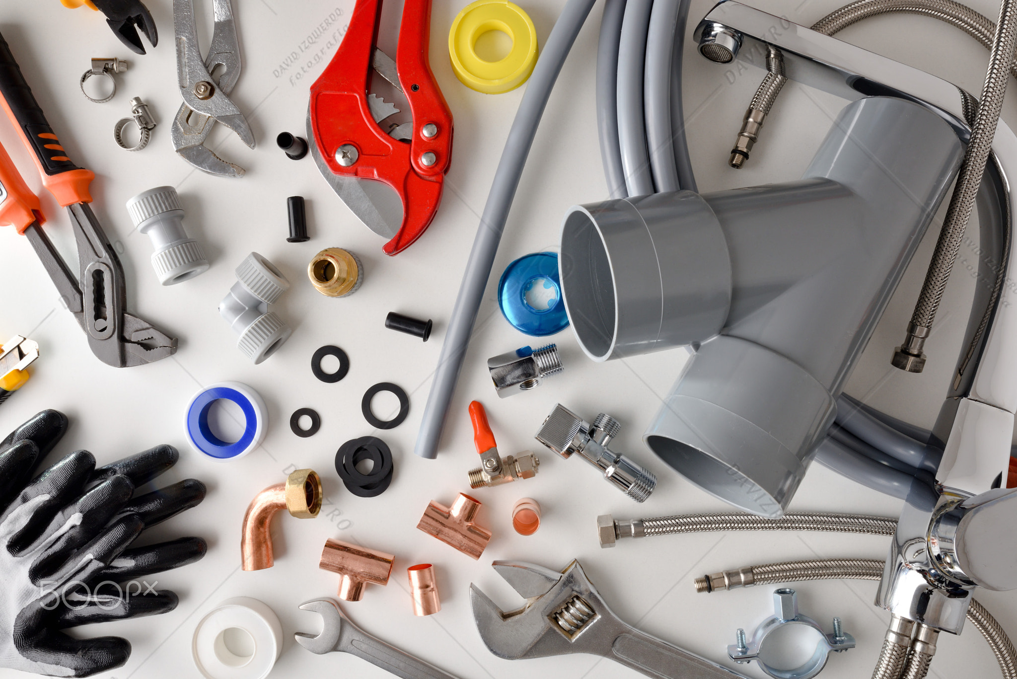 Plumbing materials and tools on white workbench top view