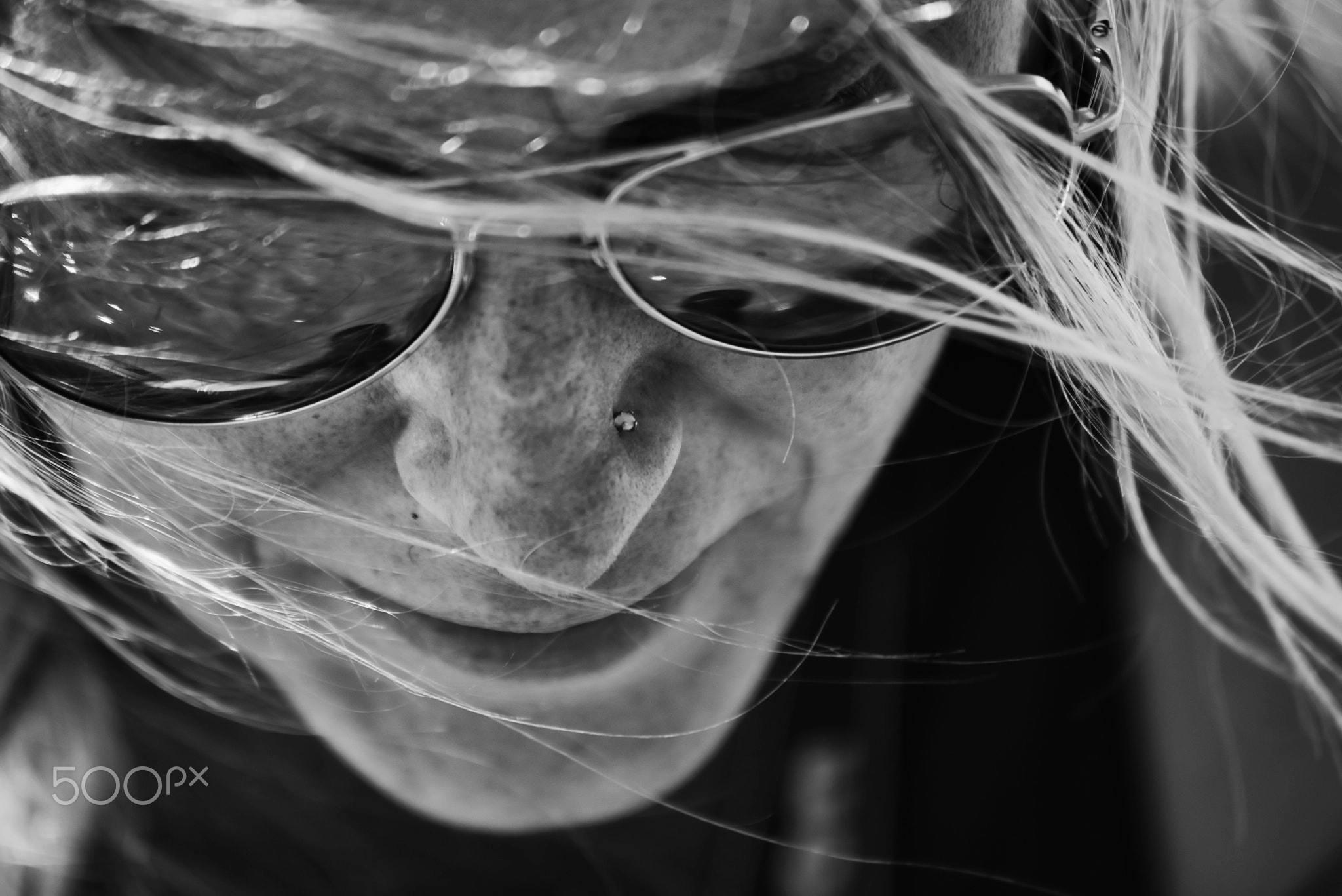 Black and white portrait photography photoshoot idea with sunglasses, wind, hair and close framing