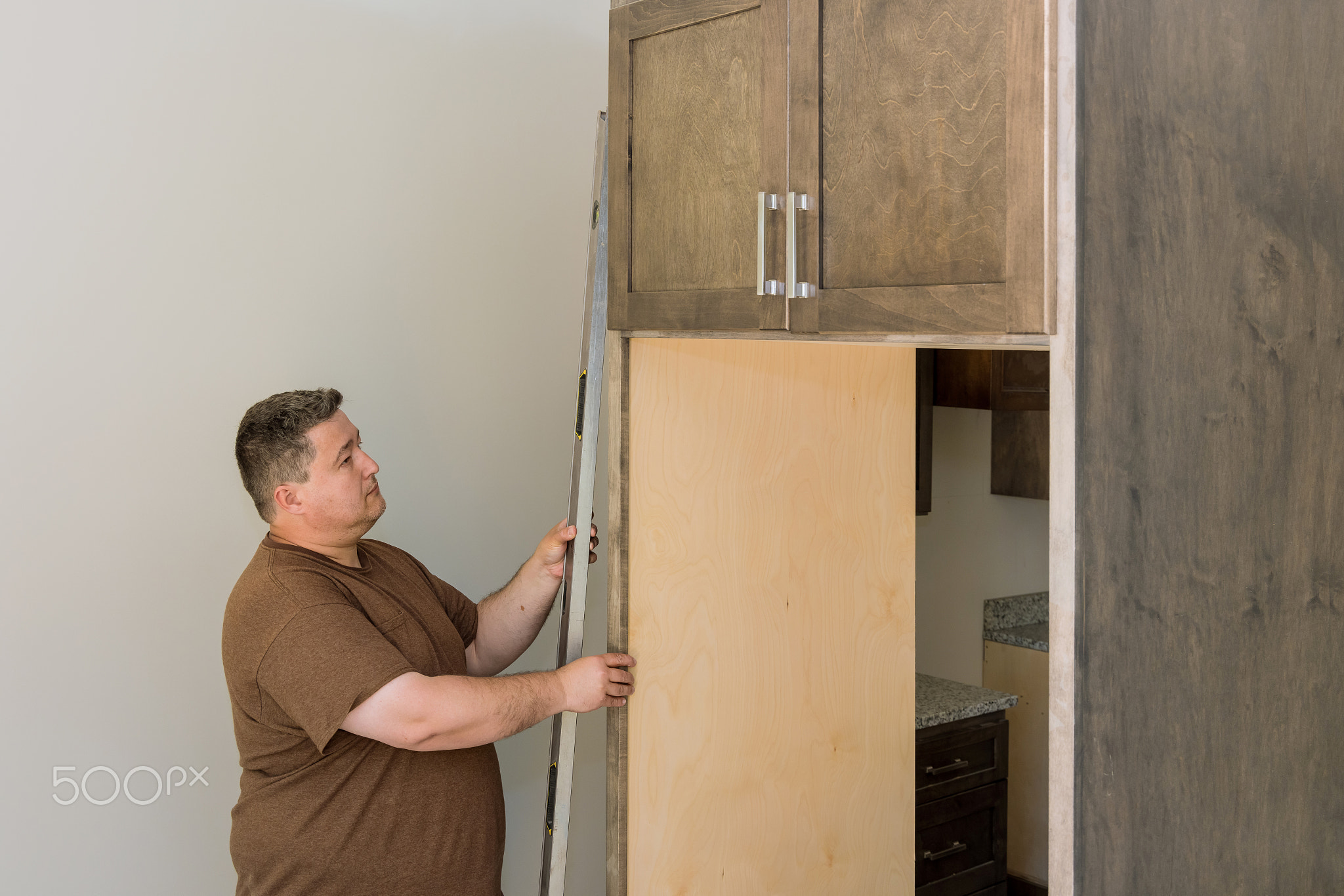 Worker hanging level the leveling kitchen cabinets