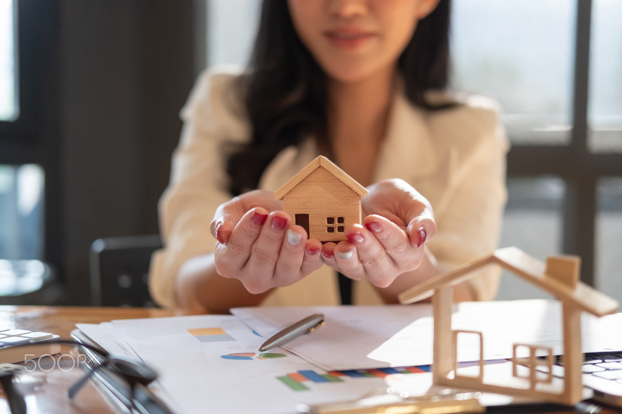 Real estate agent with house model on hans offer house. Property