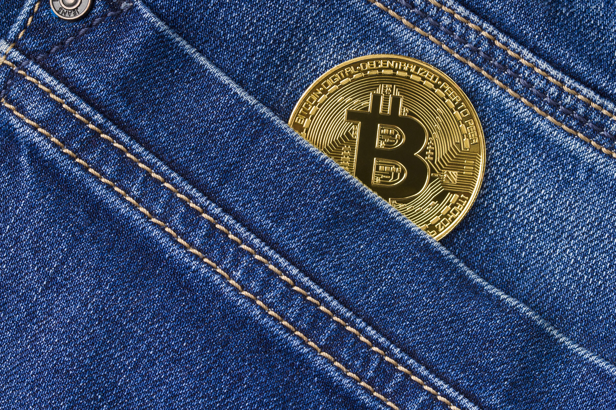 Bitcoin in a jeans pocket., close up . Virtual money, crypto currency