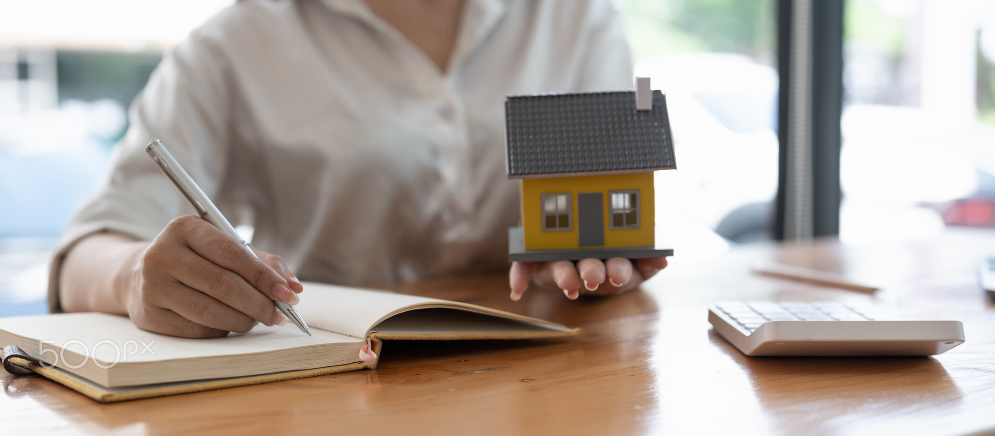 Close up real estate agent working with calculator taking note on