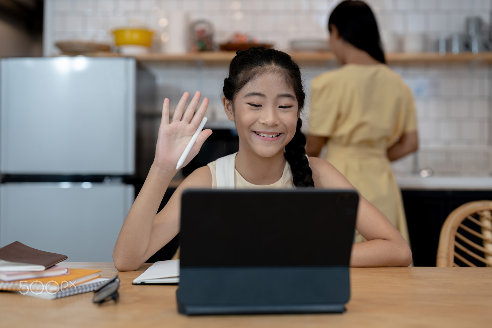 Smiling little asian girl in headphones have video call distant class