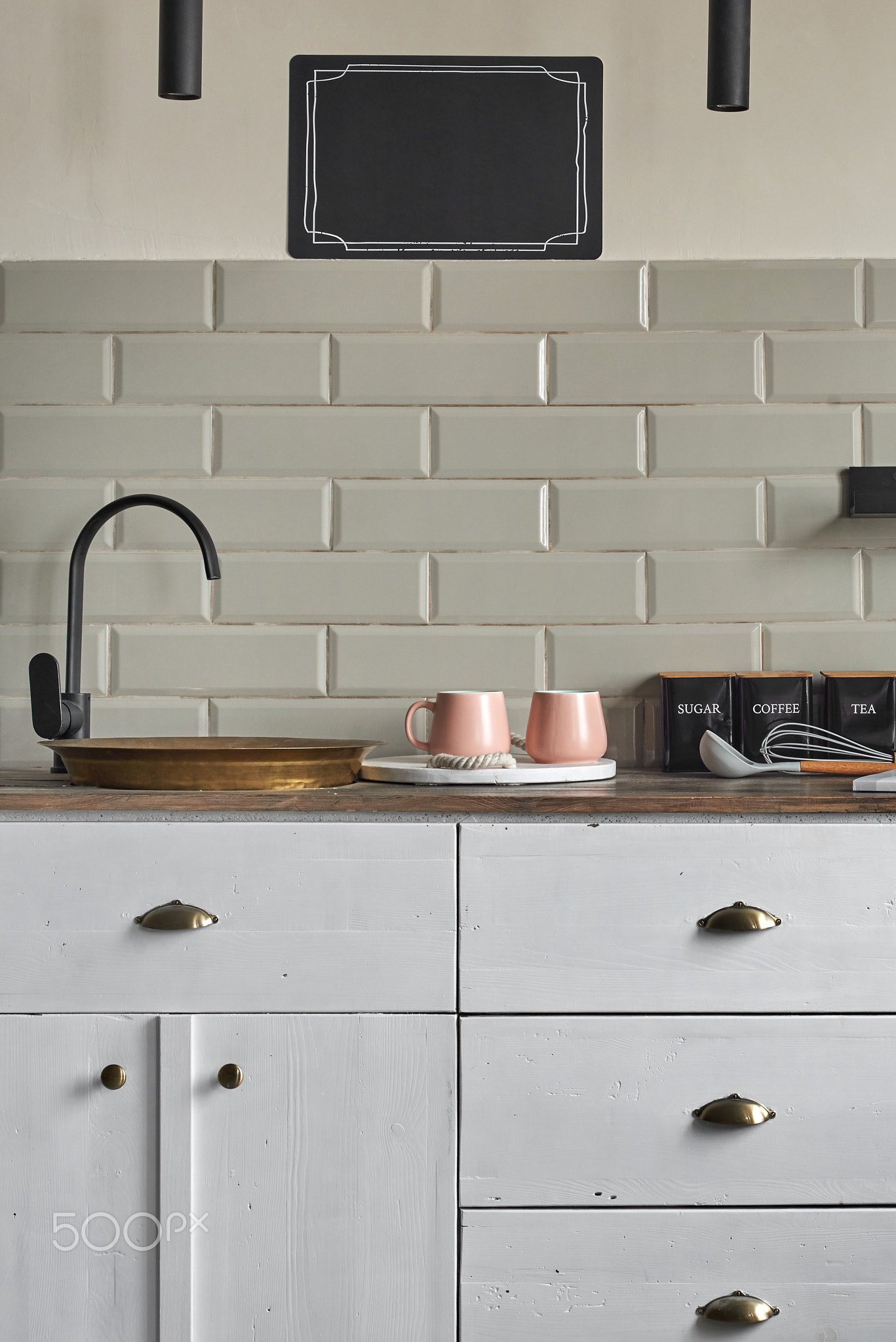 Residential house white cabinets with copper sink at kitchen counter.