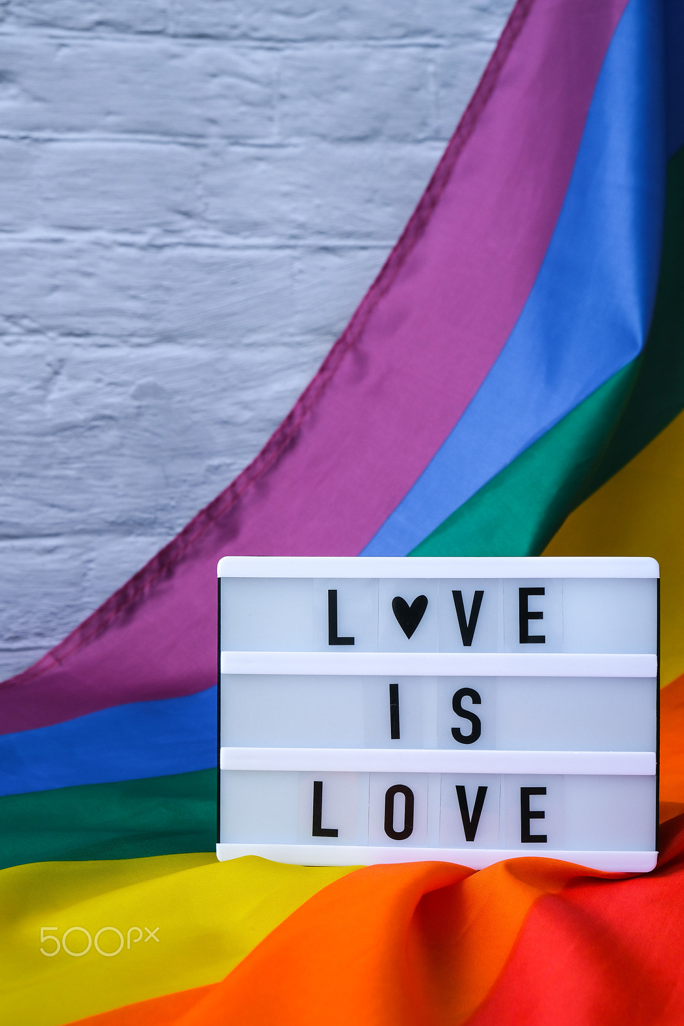 Rainbow flag with lightbox and text LOVE IS LOVE. Rainbow lgbtq flag