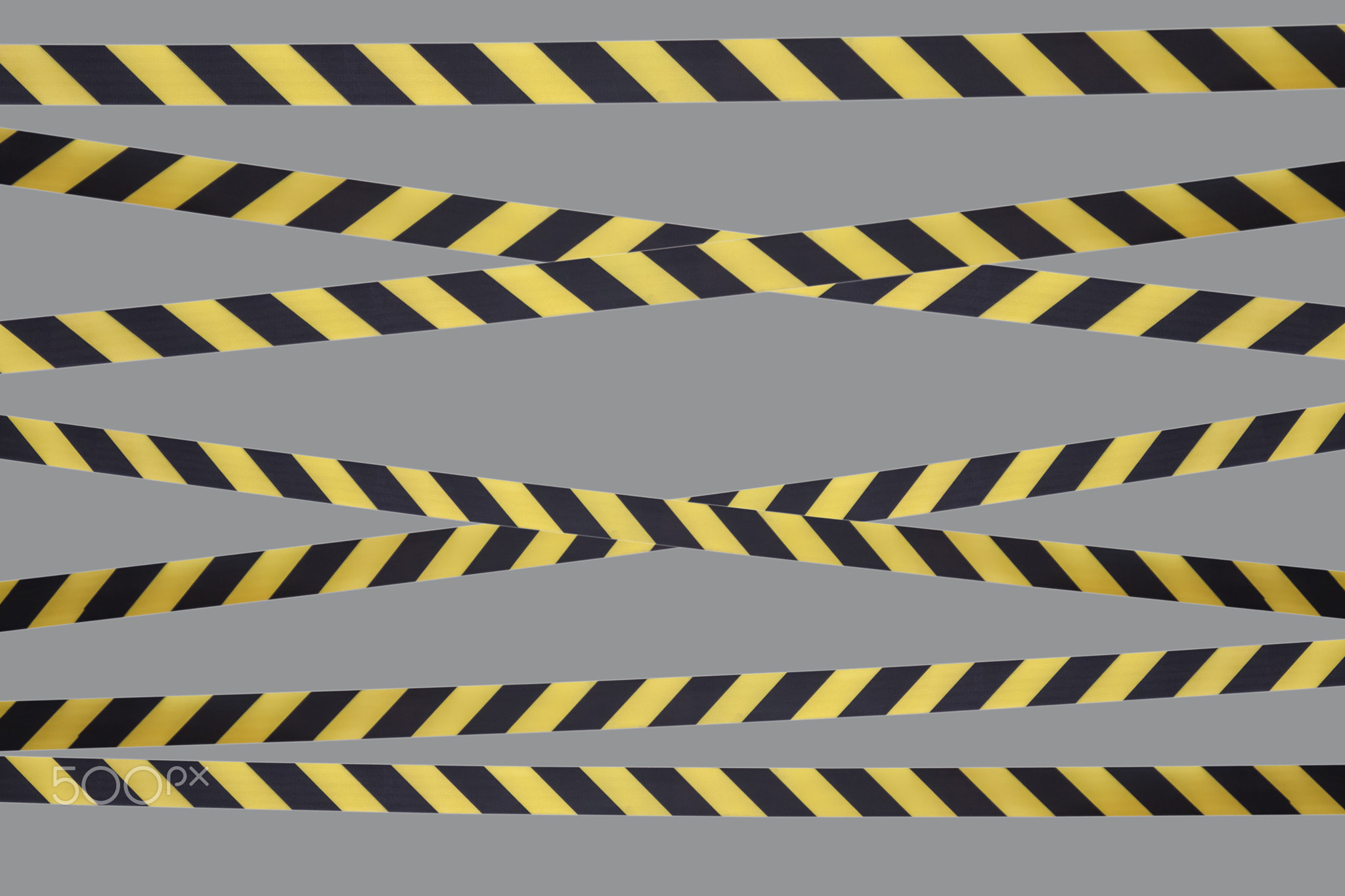 Black and yellow warning lines of barrier tape prohibit passage