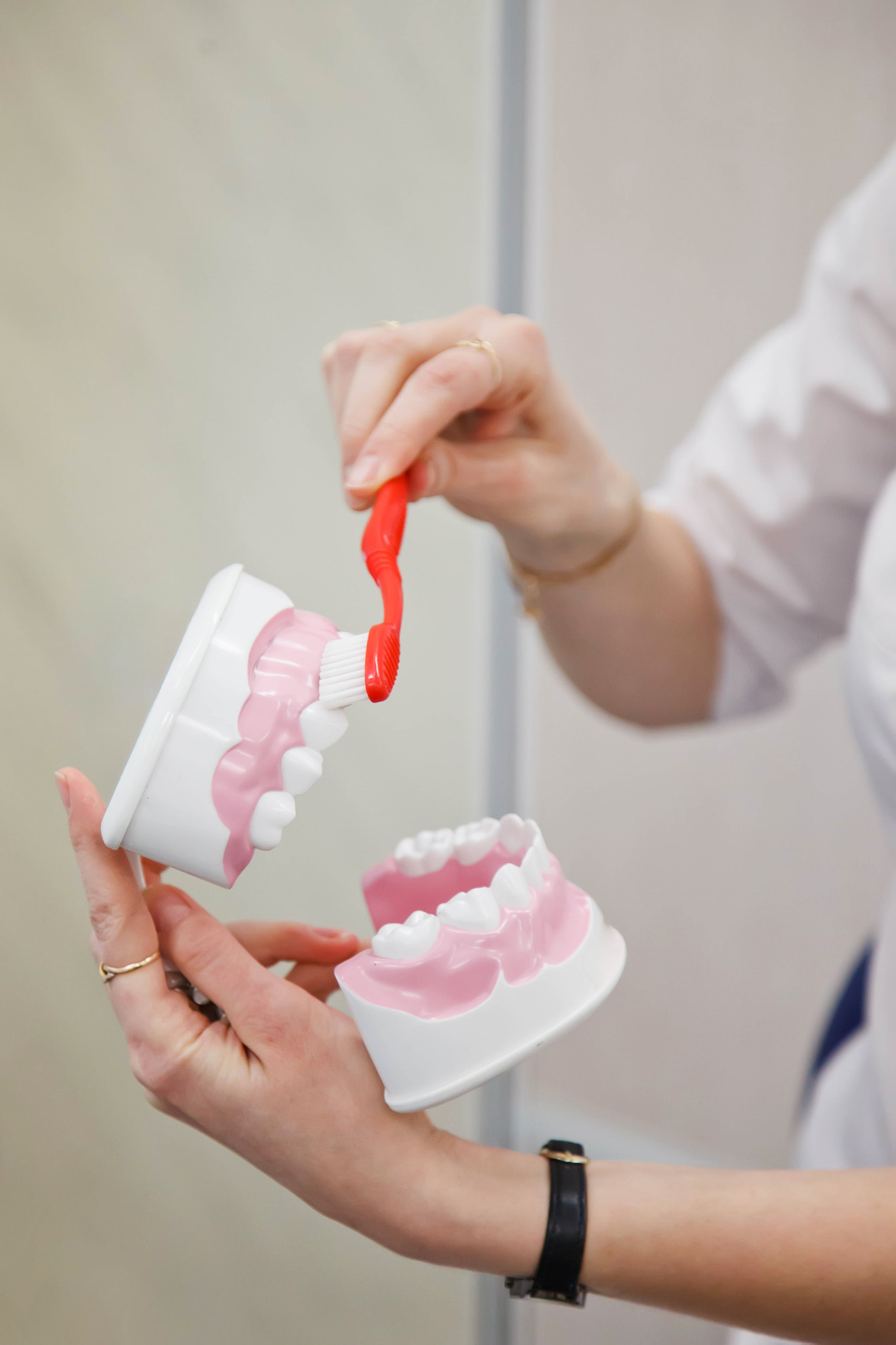 Female dentist prosthetist shows rules for brushing teeth