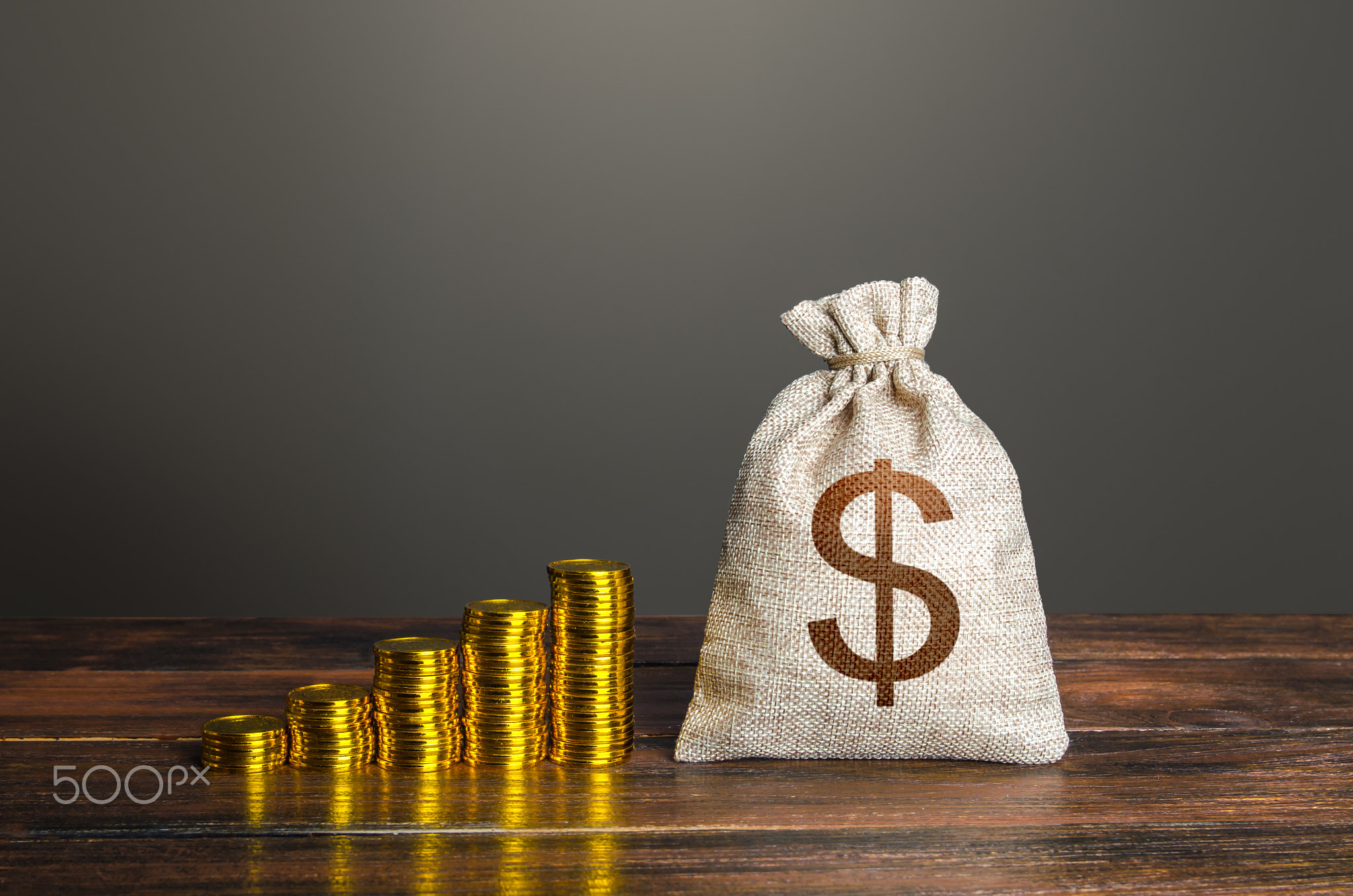 Dollar money bag and increasing stacks of coins.