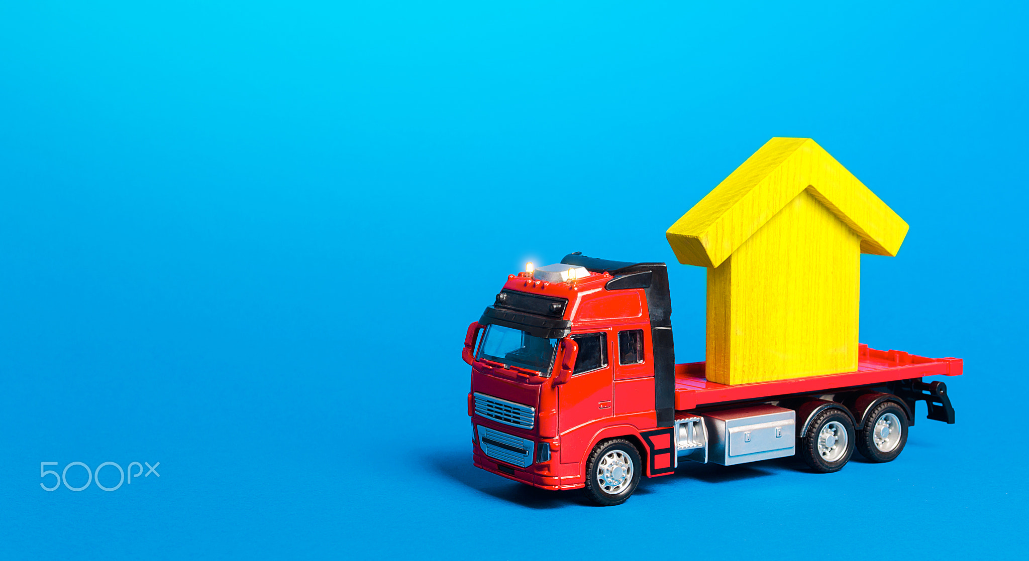 Red freight truck carrier with a yellow house figure.
