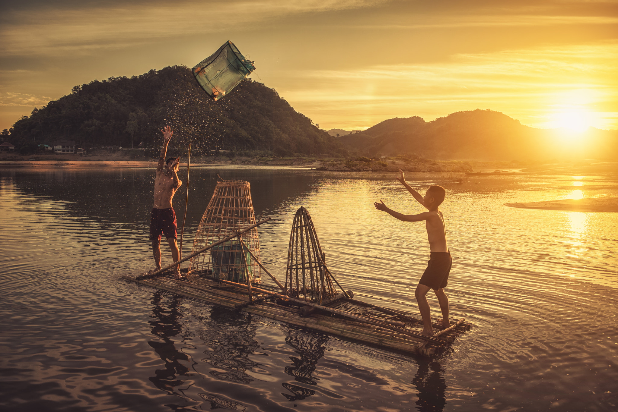 Boys fishing at the river by Sasin Tipchai