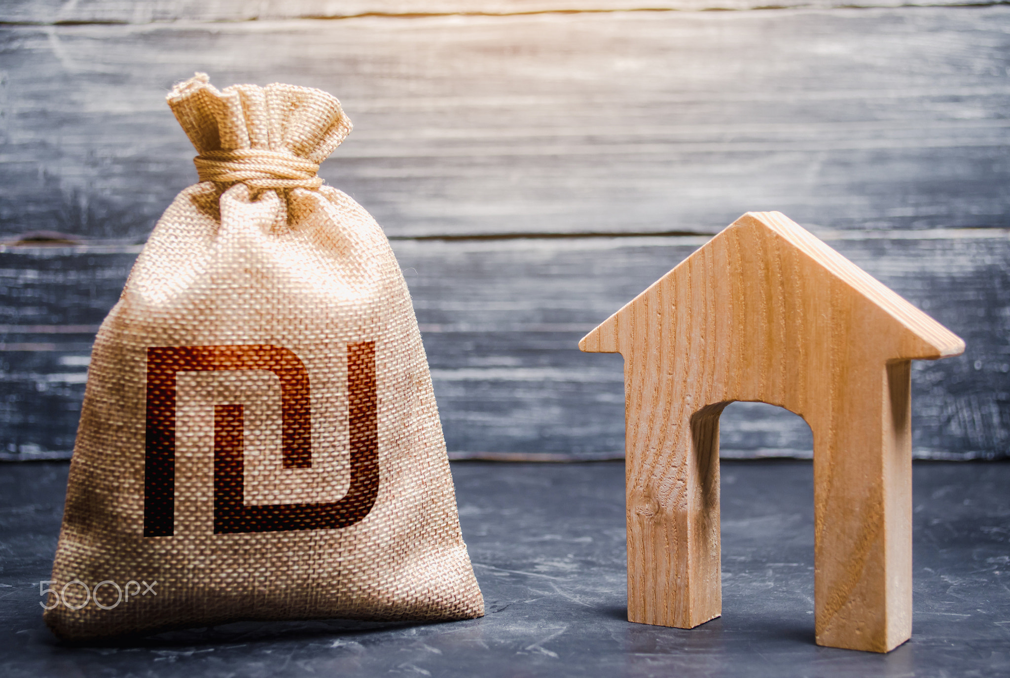 Wooden house and a israeli shekel money bag.