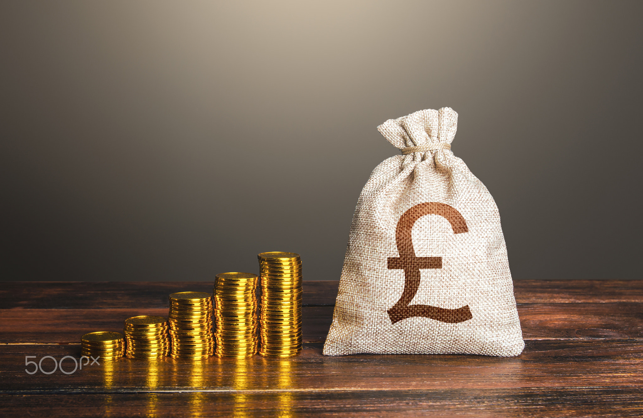 British pound sterling money bag and increasing stacks of coins