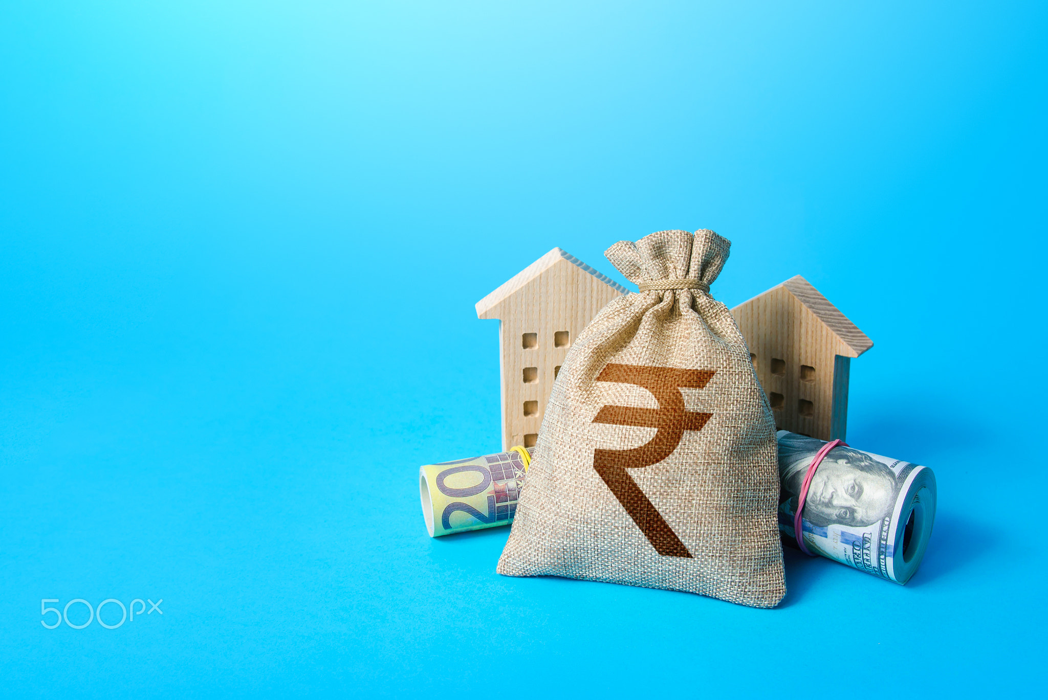 Houses and indian rupee money bag.