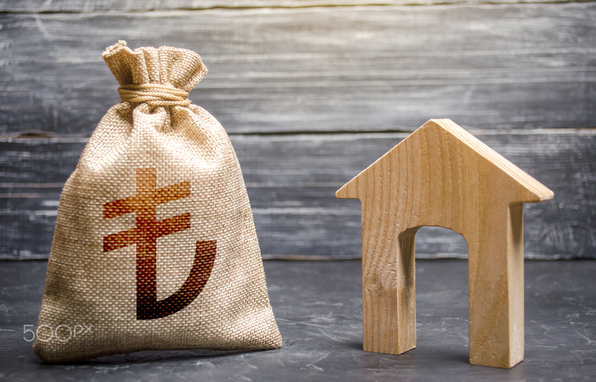 Wooden house and a turkish lira money bag.