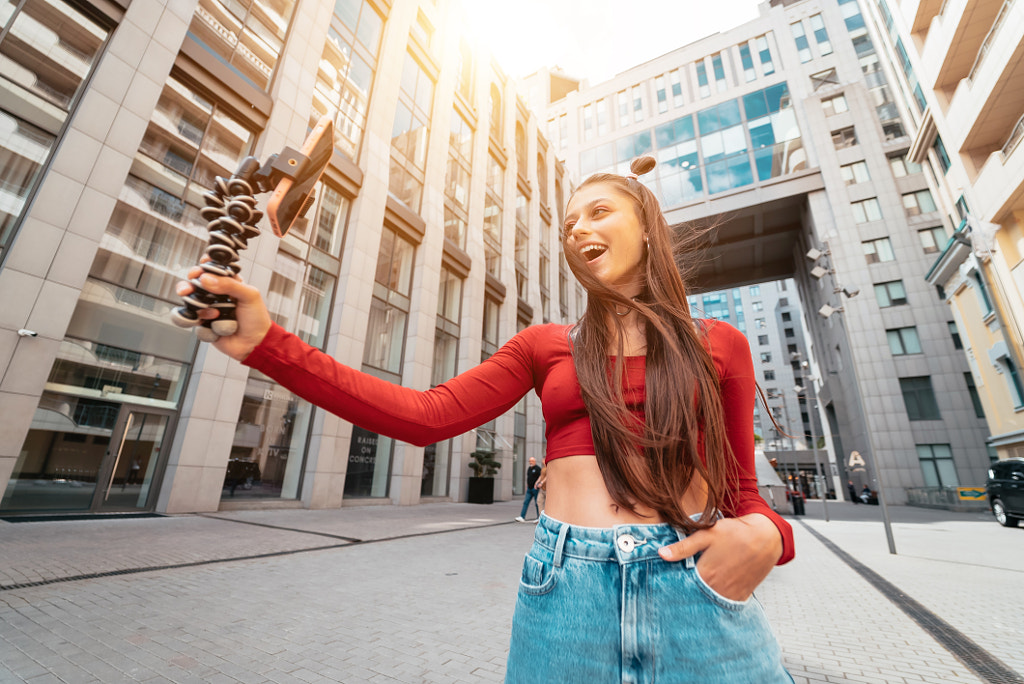 Young female blogger with smartphone streaming on the street. by Oleksii Hrecheniuk on 500px.com