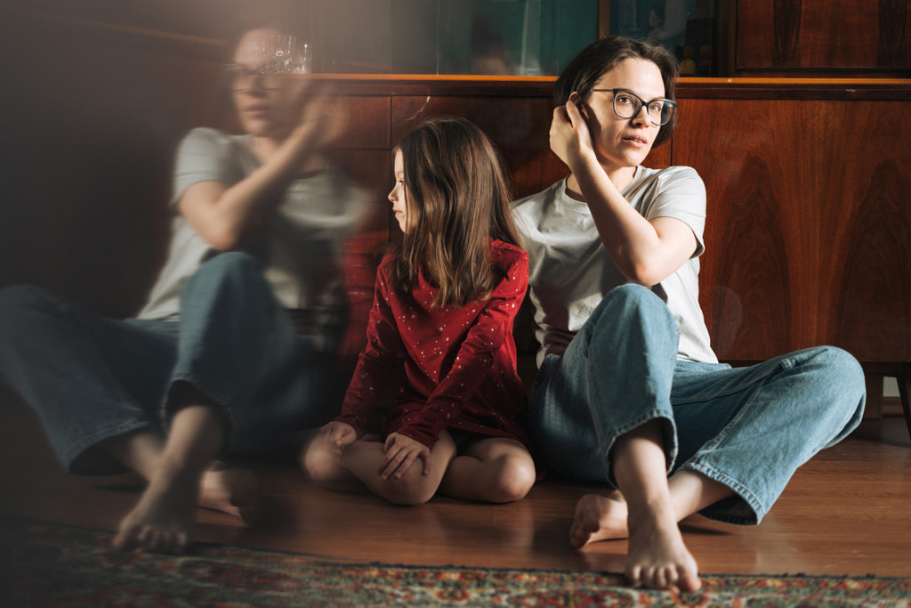 Tween girl and mother sitting on the floor in living room at the home, child looking on reflextion par Galina Zhigalova sur 500px.com