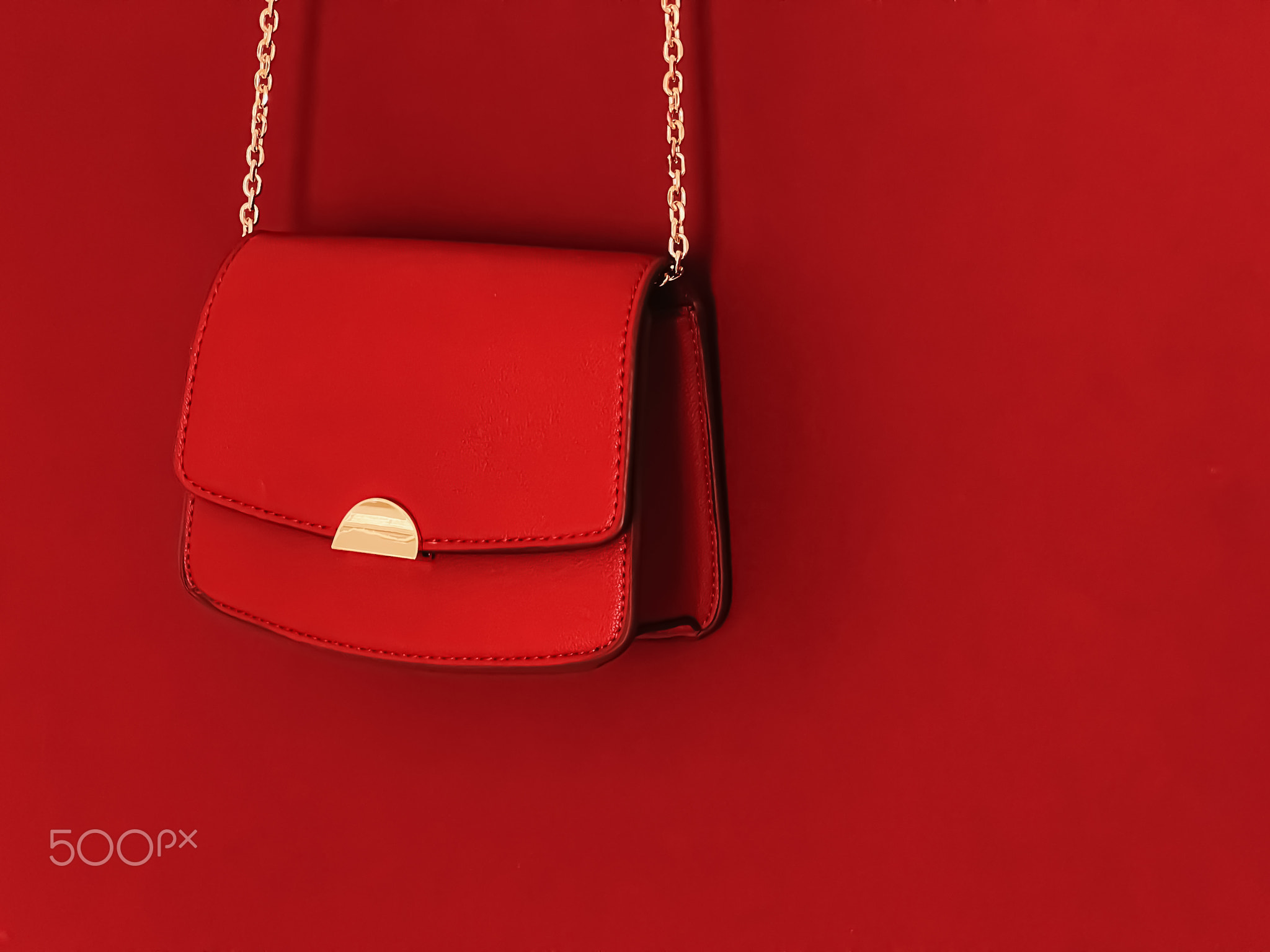 Red fashionable leather purse with gold details as designer bag and