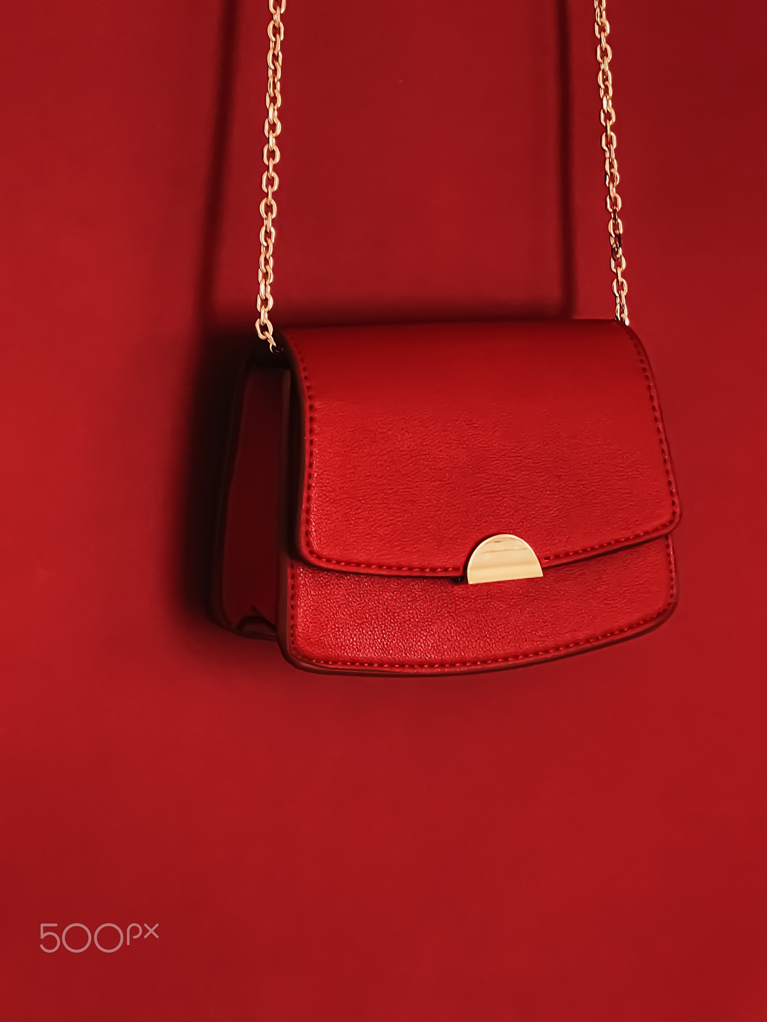 Red fashionable leather purse with gold details as designer bag and