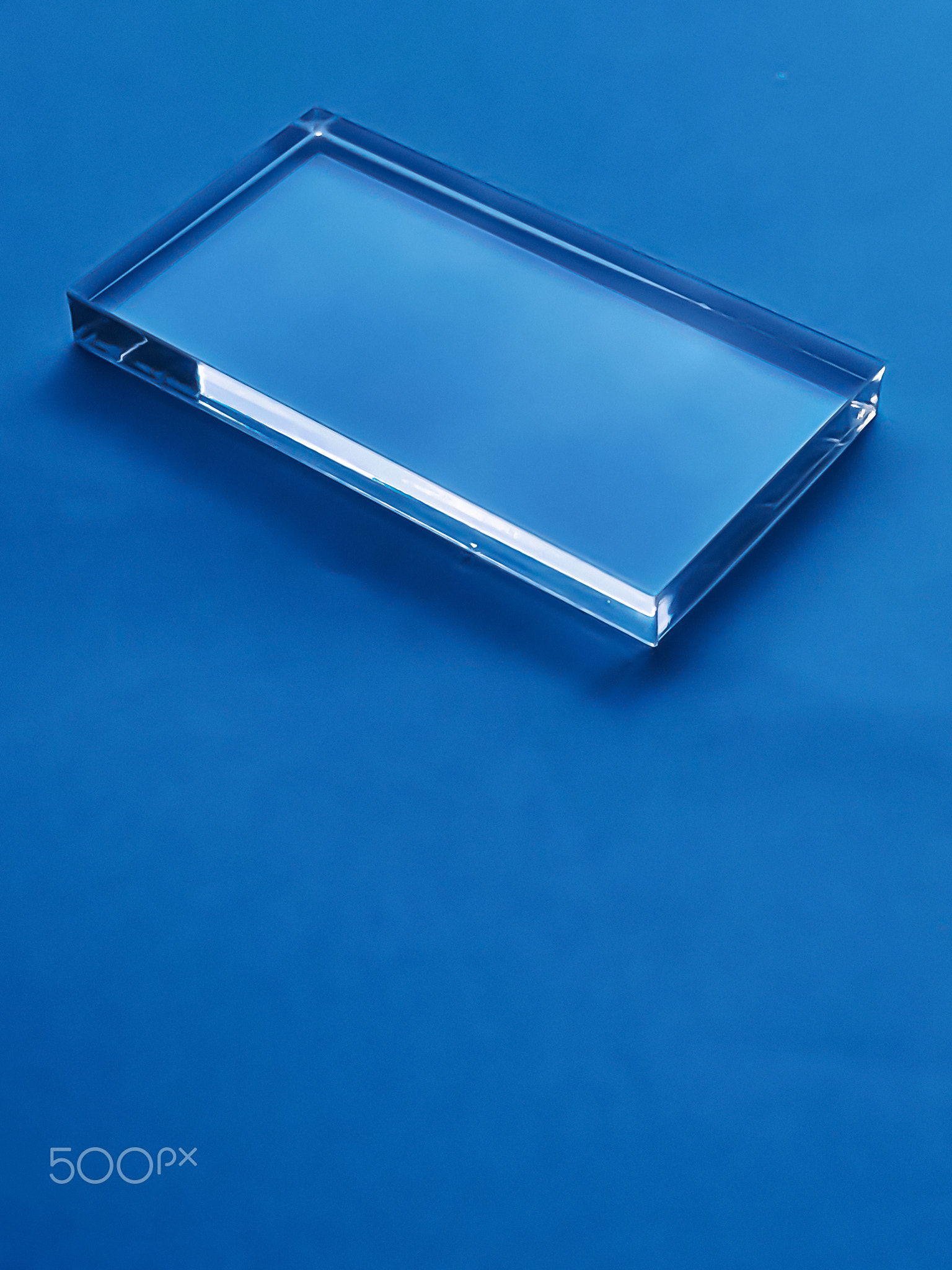 Transparent glass device on blue background, future technology and