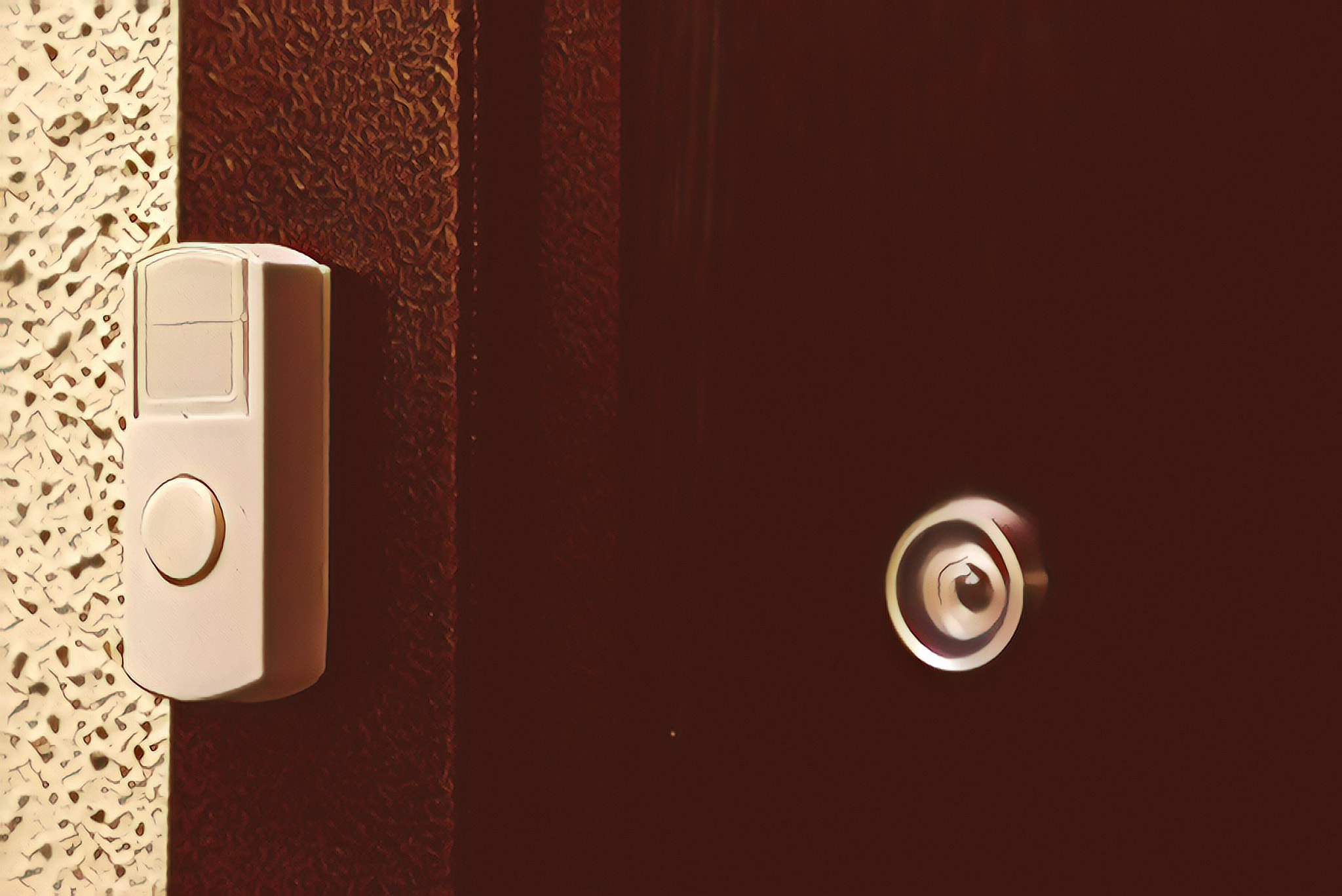 White doorbell or buzzer button on door next to peephole
