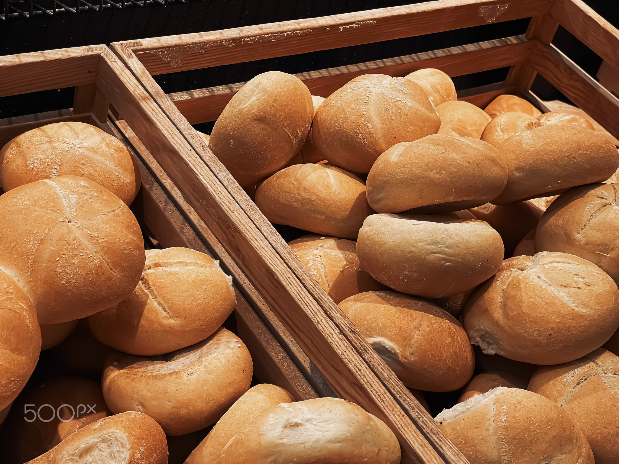 Fresh loaves of bread and buns in rustic bakery, baked goods on rustic