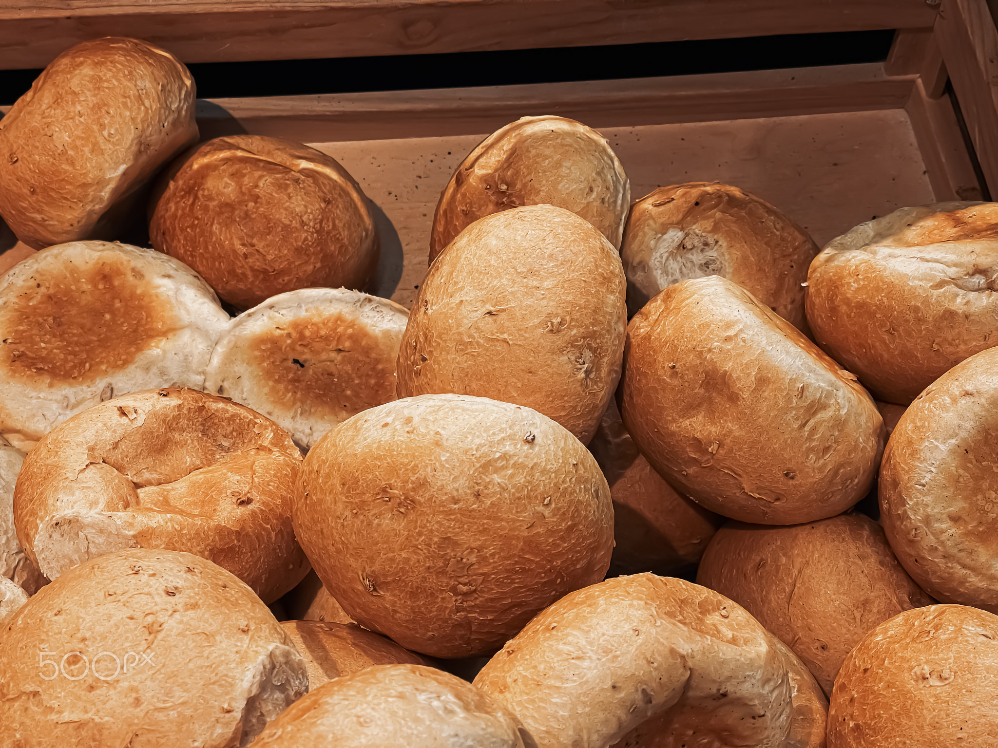 Fresh loaves of bread and buns in rustic bakery, baked goods on rustic