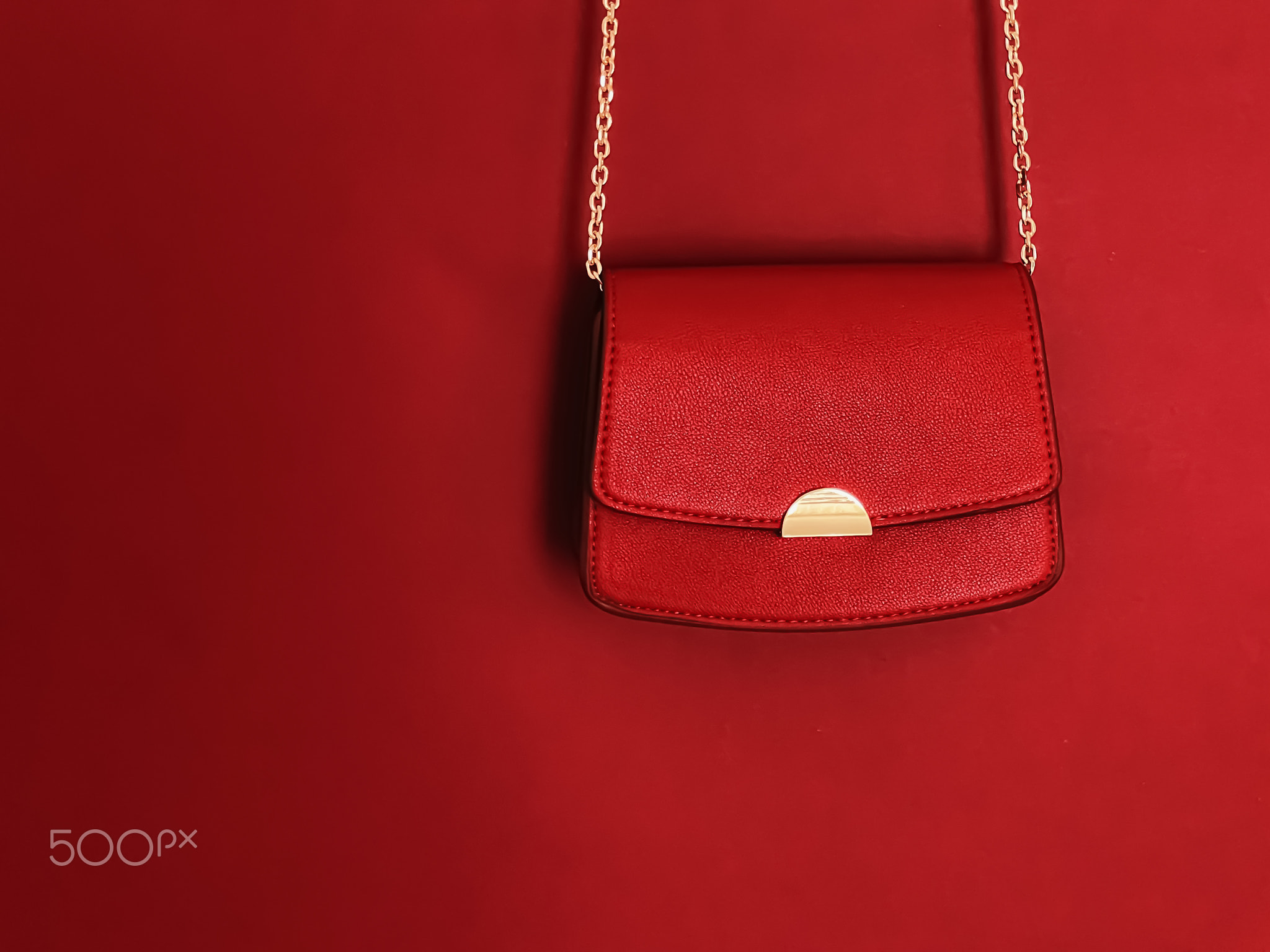 Red fashionable leather purse with gold details as designer bag and
