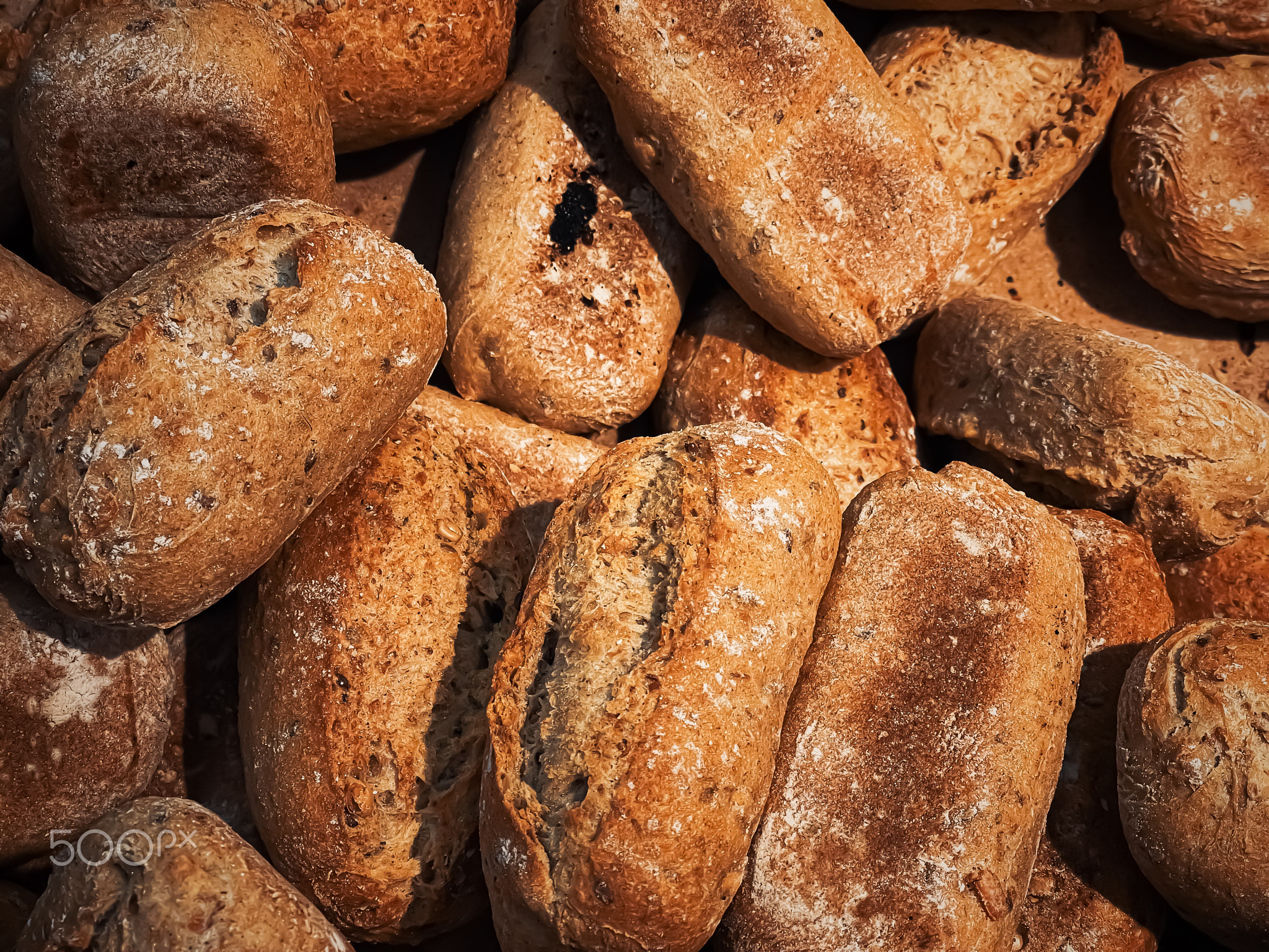 Fresh loaves of bread and buns in rustic bakery, baked goods on rustic