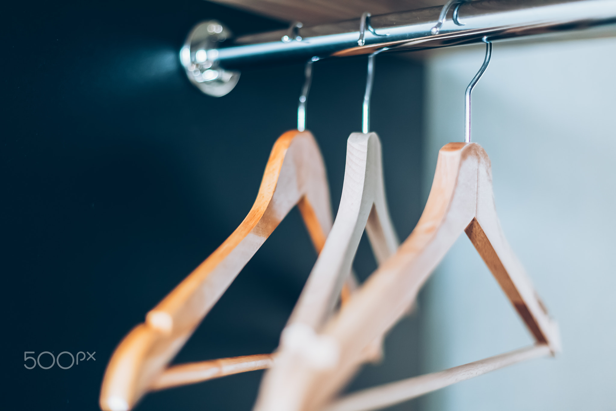 Empty Wooden hangers on rail in closet