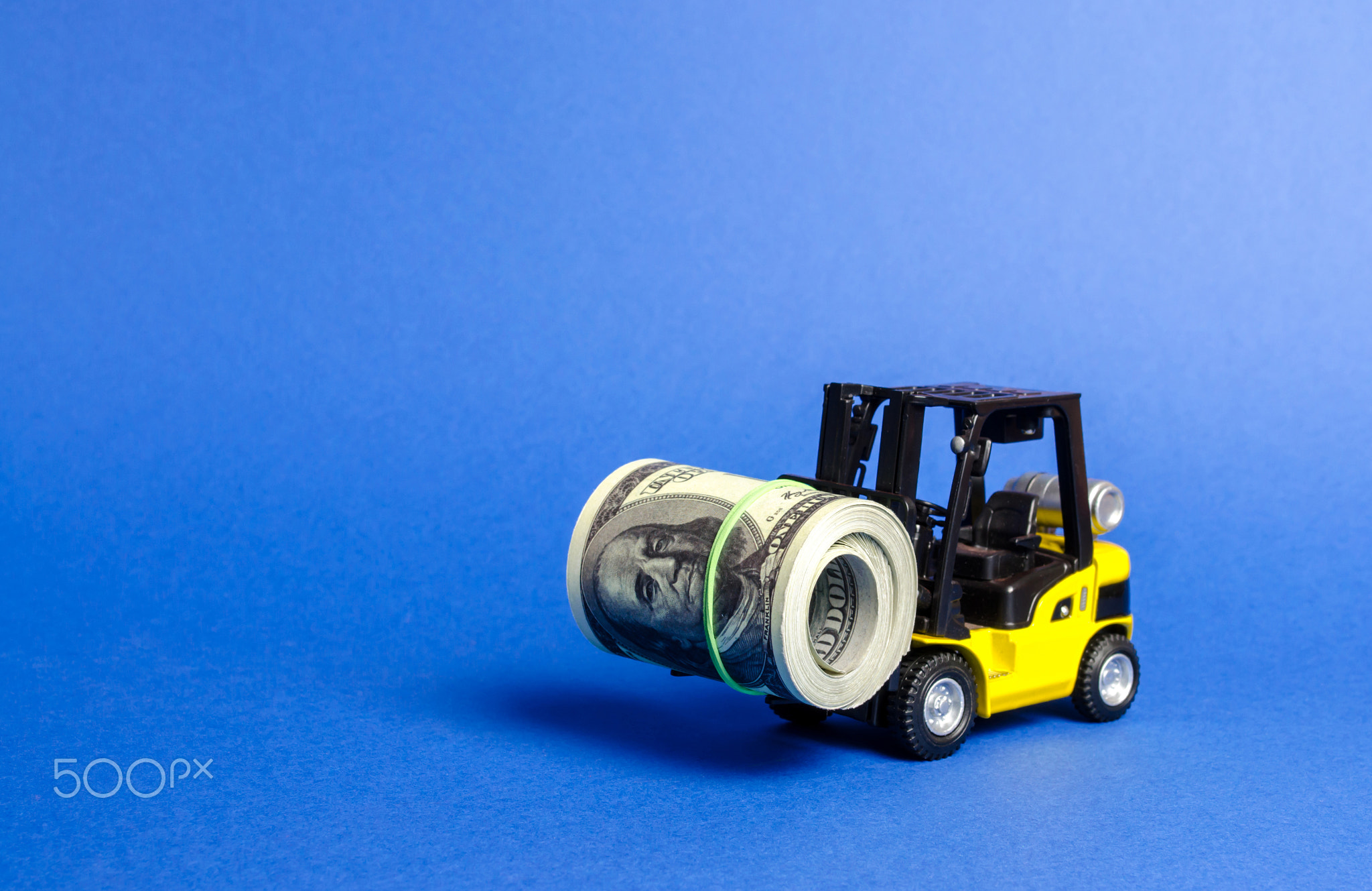 Forklift truck carries a bundle of dollars.
