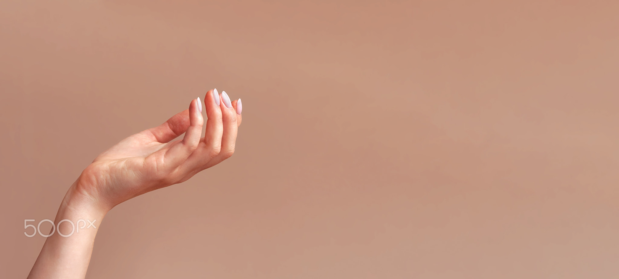 Woman's hand mockup on beige background. Minimalistic natural feminine
