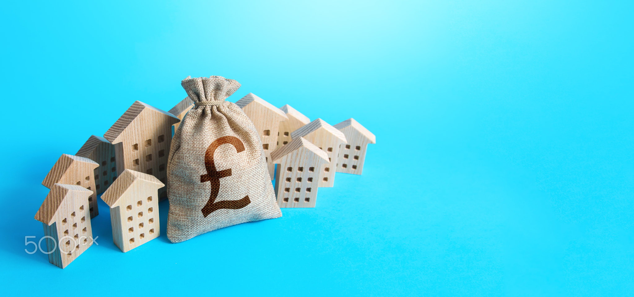 British pound sterling money bag surrounded by houses.