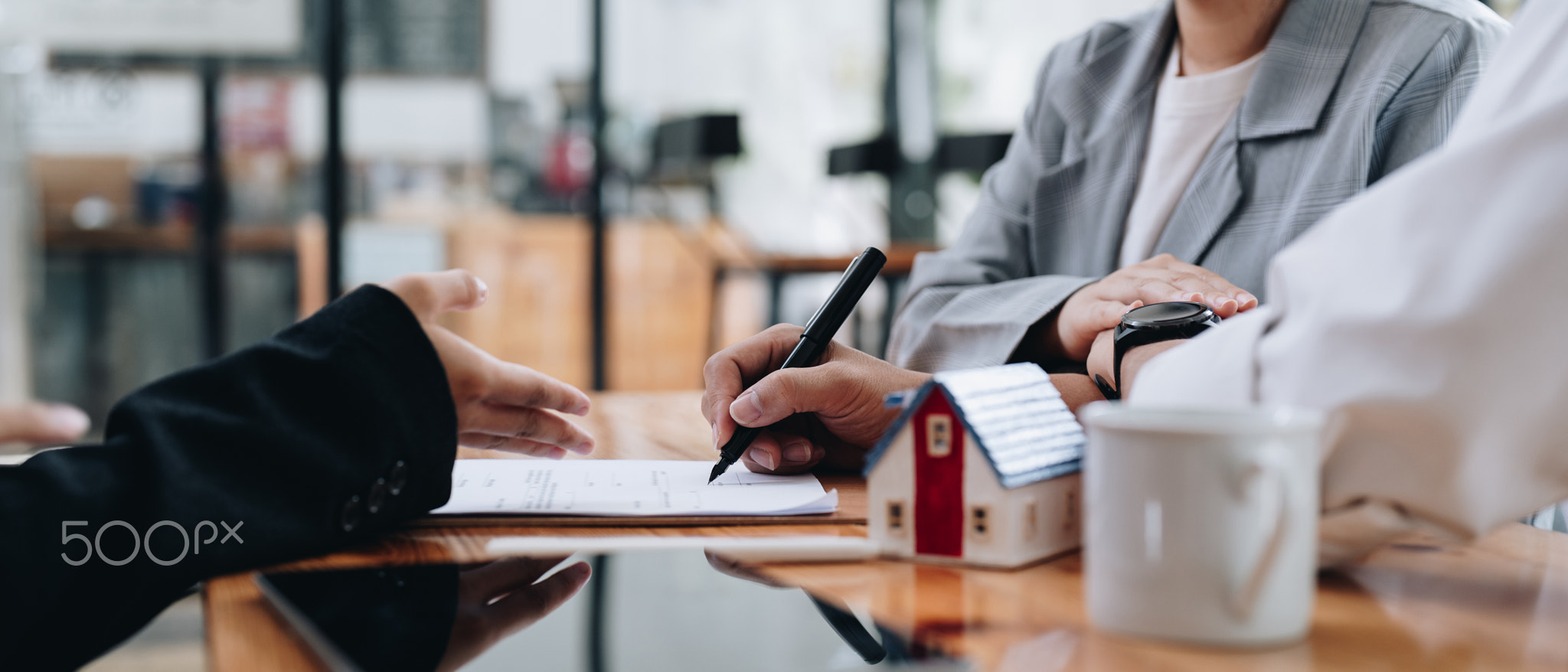 Business woman and young couple signing agreement for buying house