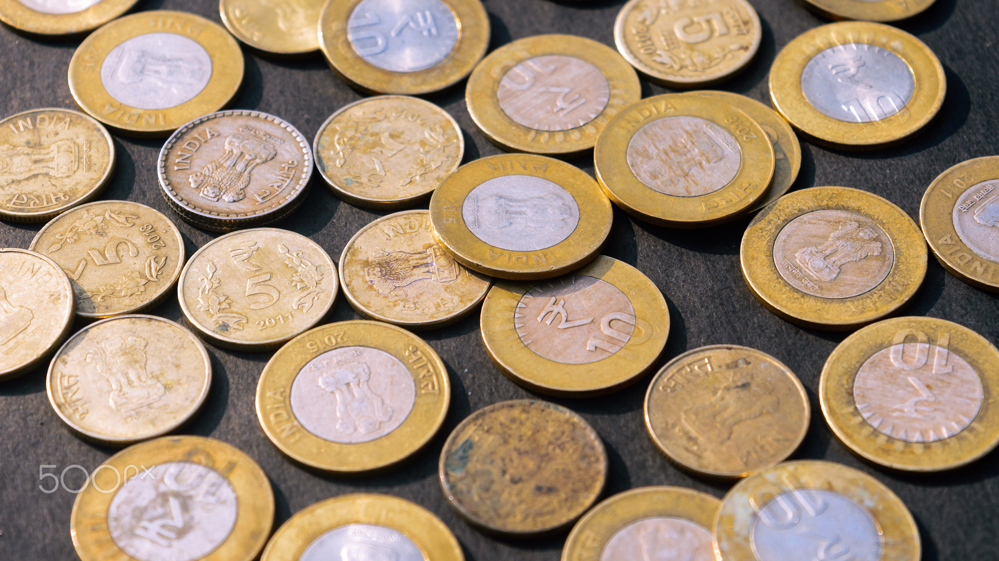 Indian Rupee Coin currency on rustic floor. Full Frame.