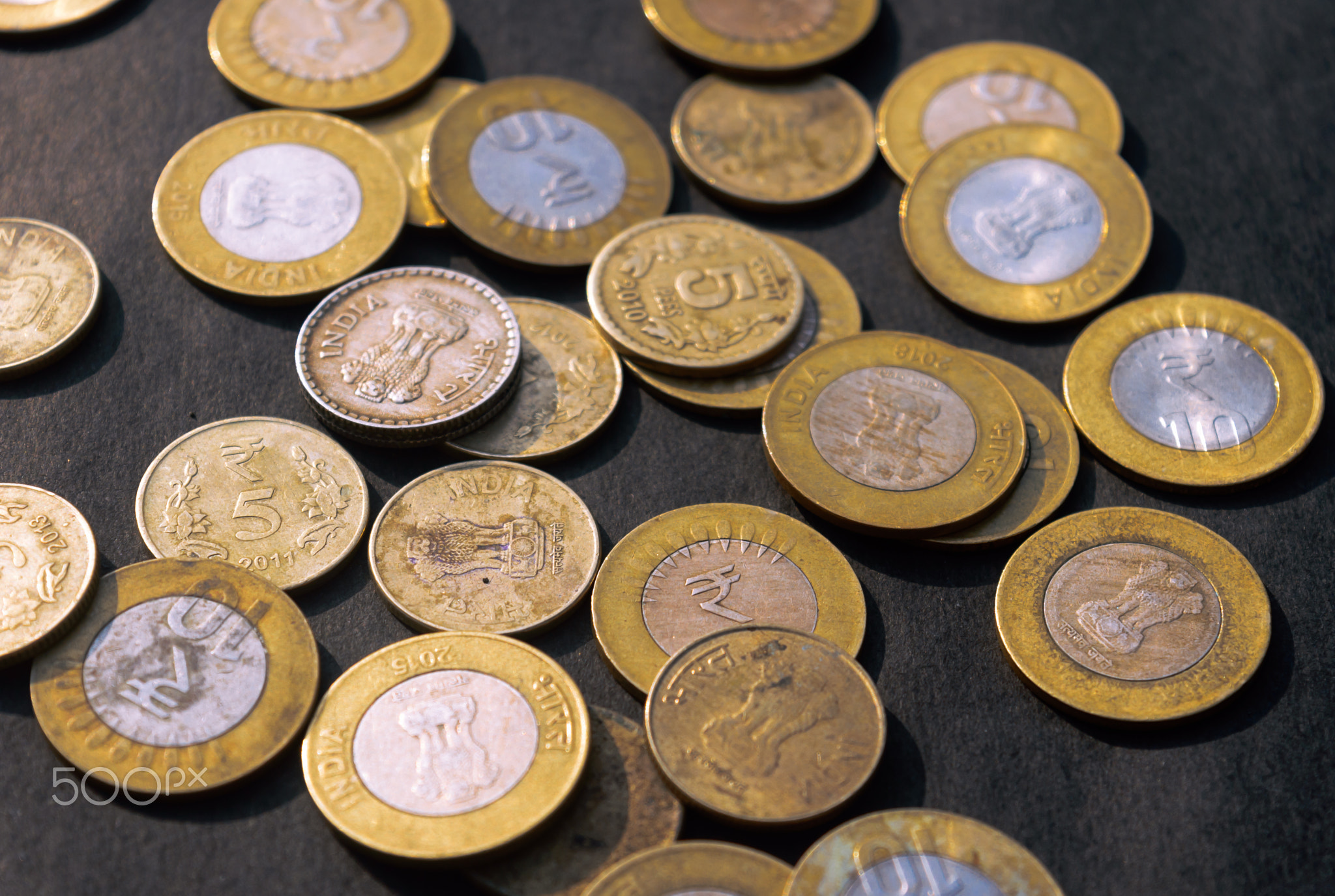 Indian Rupee Coin currency on rustic floor. Full Frame.