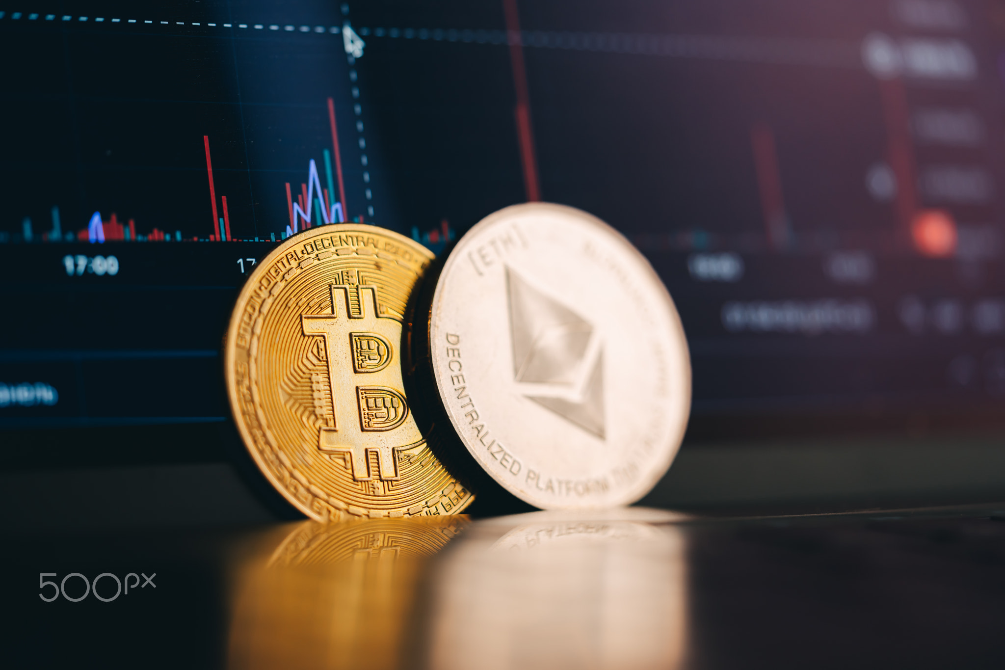 Cryptocoins near laptop with chart.