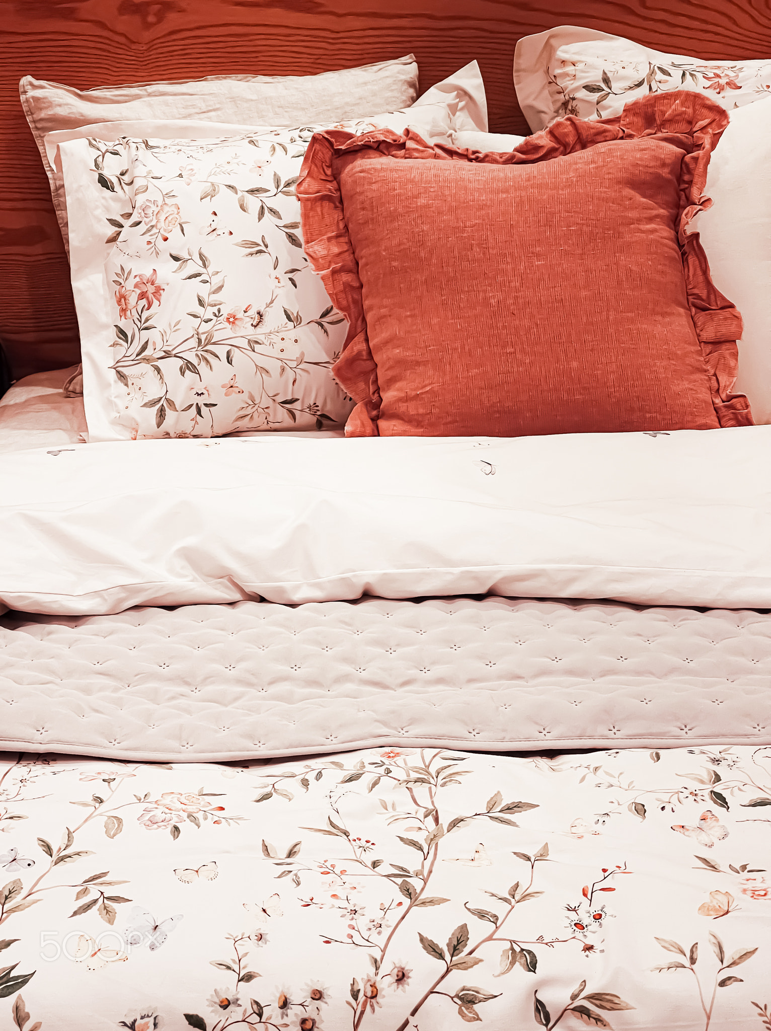 Vintage countryside style bedding with floral pattern on wooden bed in