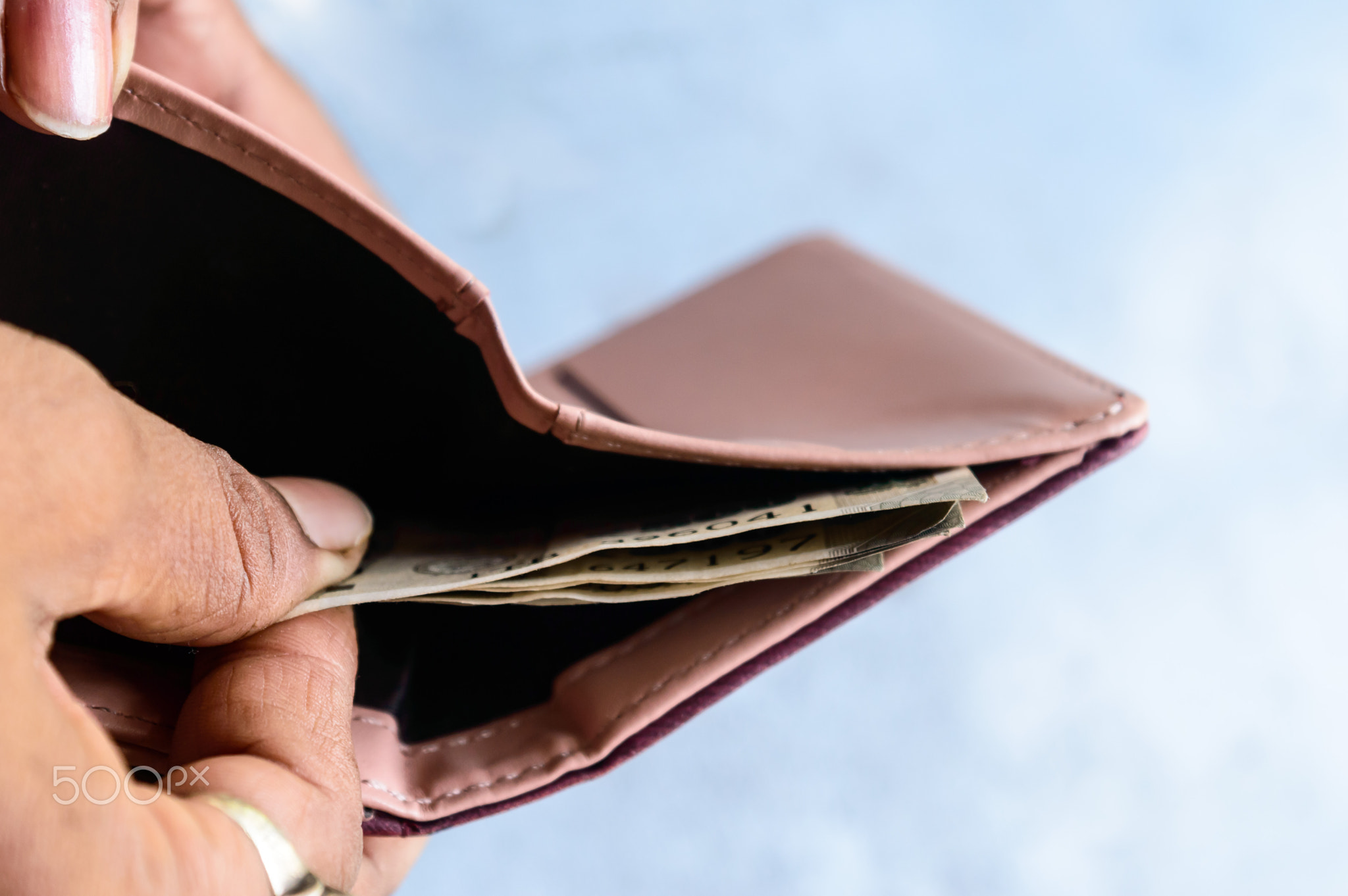 paying Indian rupee banknotes from leather wallet.