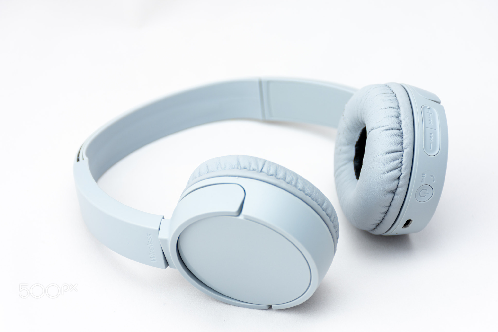 Close-up of gray wireless headphones isolated on white background.